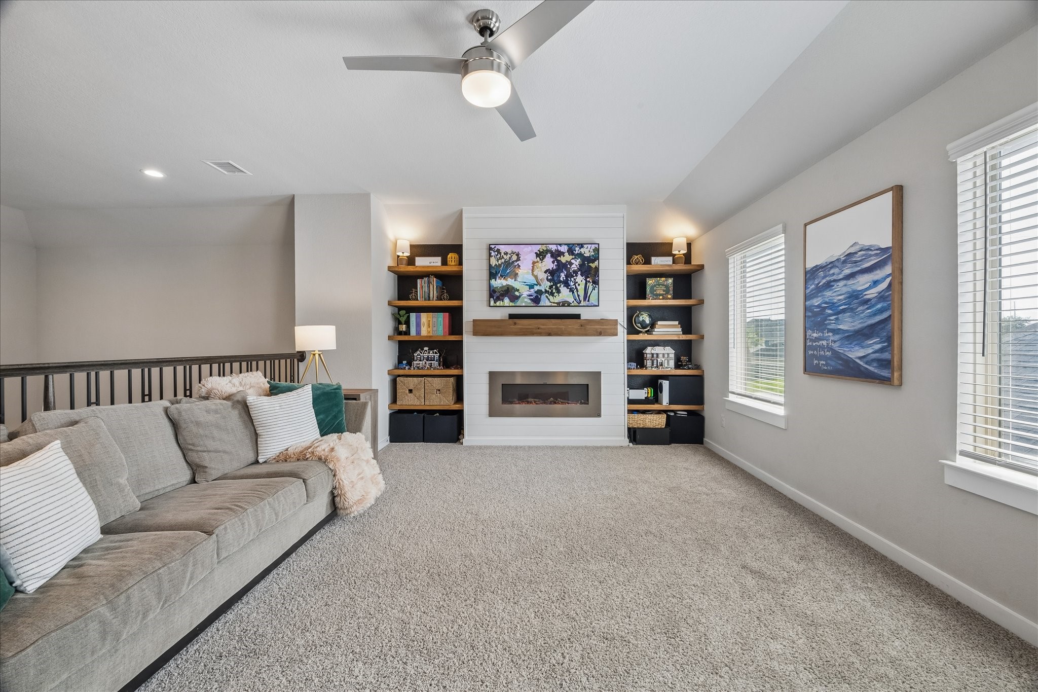 Must See! Open game room overlooking the living area below, enhanced with custom built-ins, a shiplap fireplace, and a mantel for warm, inviting gathering space.