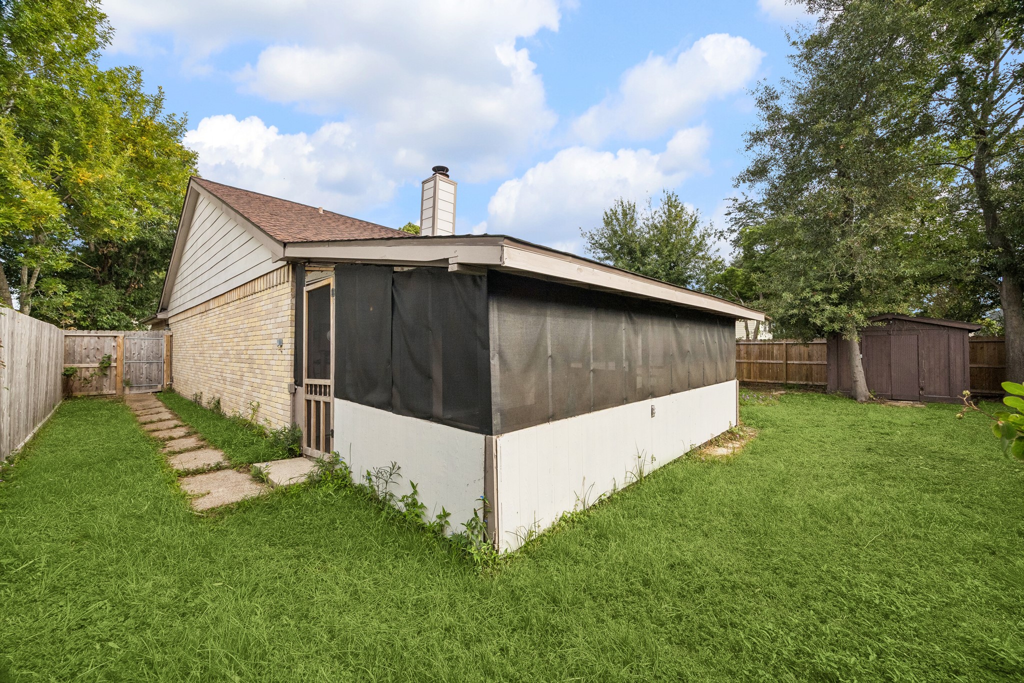 Side yard has paver path for guest access to screened-in porch