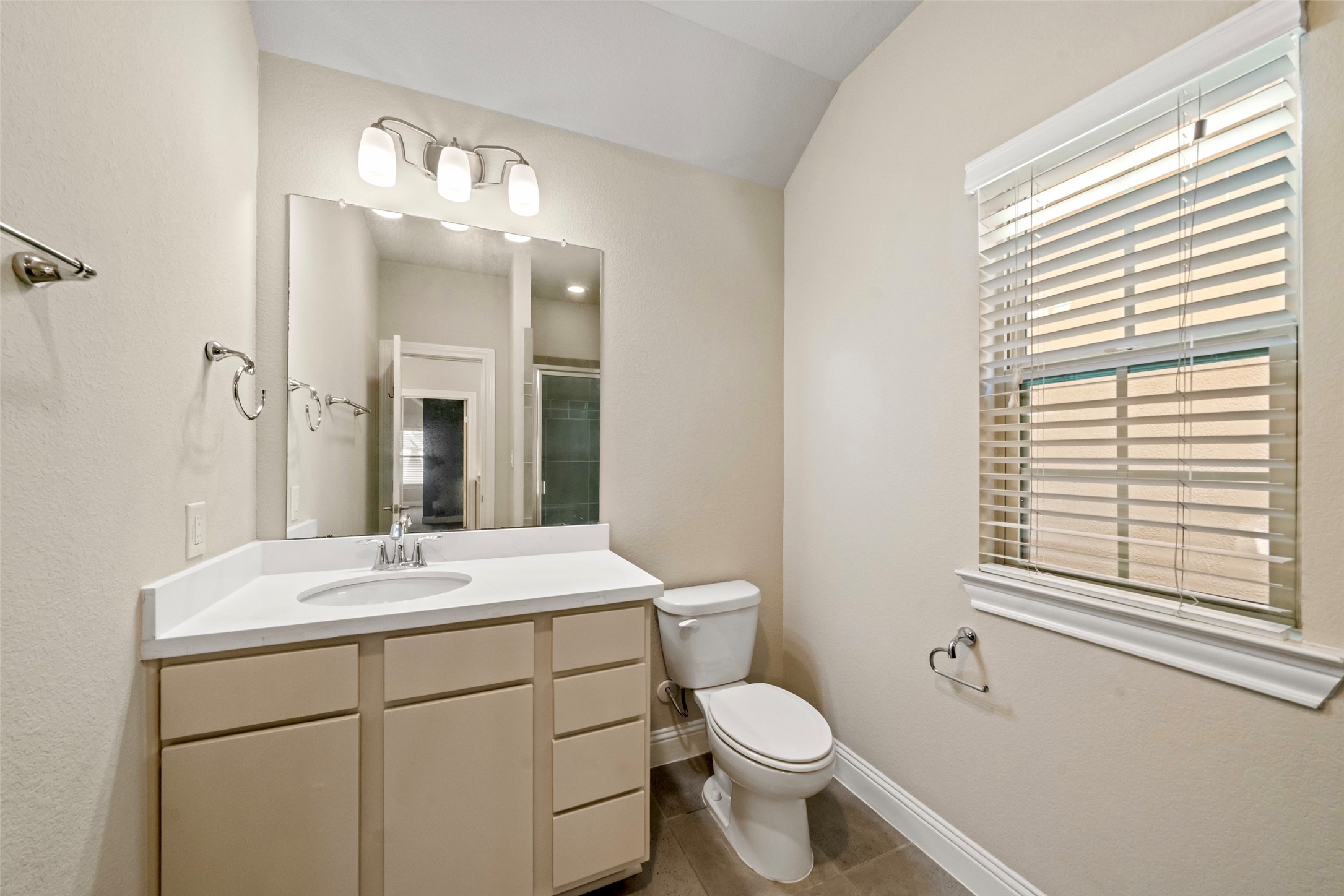 The third floor bathroom is completely updated with cool tones, fixtures and features a standing shower.