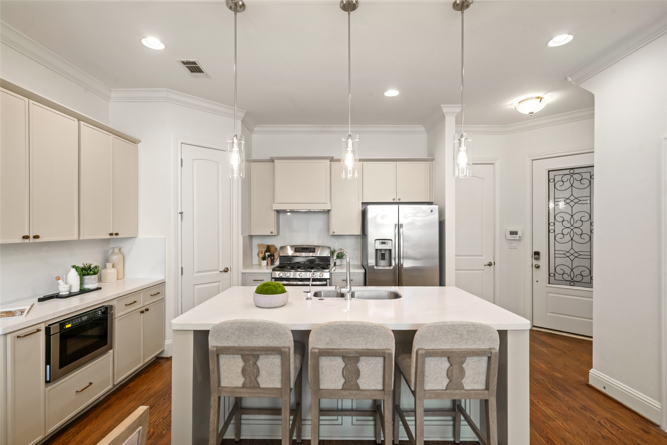 Completely updated kitchen with gorgeous quartz counters, stainless appliance, bar for a quick bit, custom vent hood, and built-in microwave drawer.