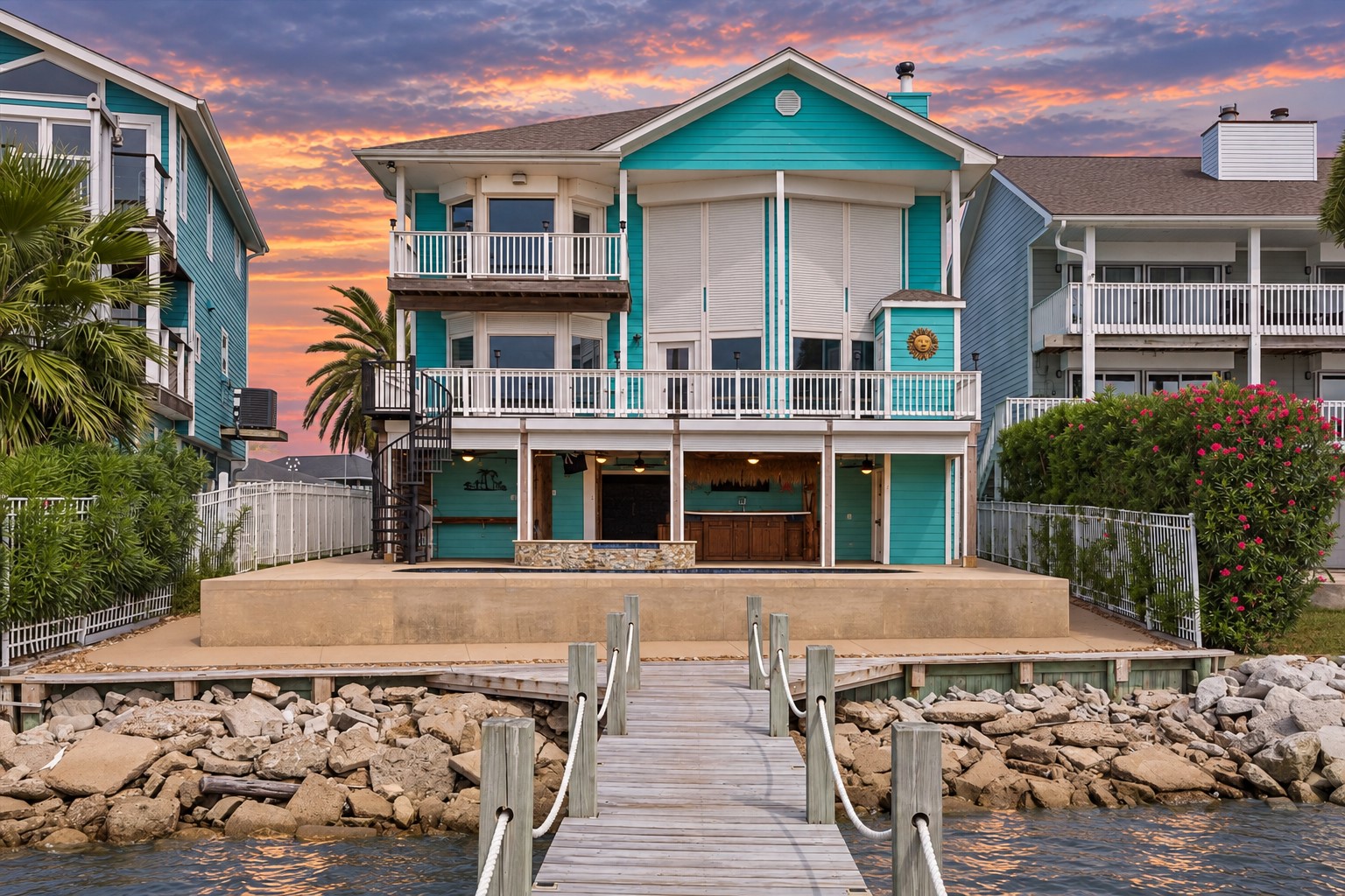 THE WATERFRONT POOL AND RAISED SPA OVERLOOK THE PRIVATE PIER AND TWO-LEVEL PALAPA-COVERED DOCK.