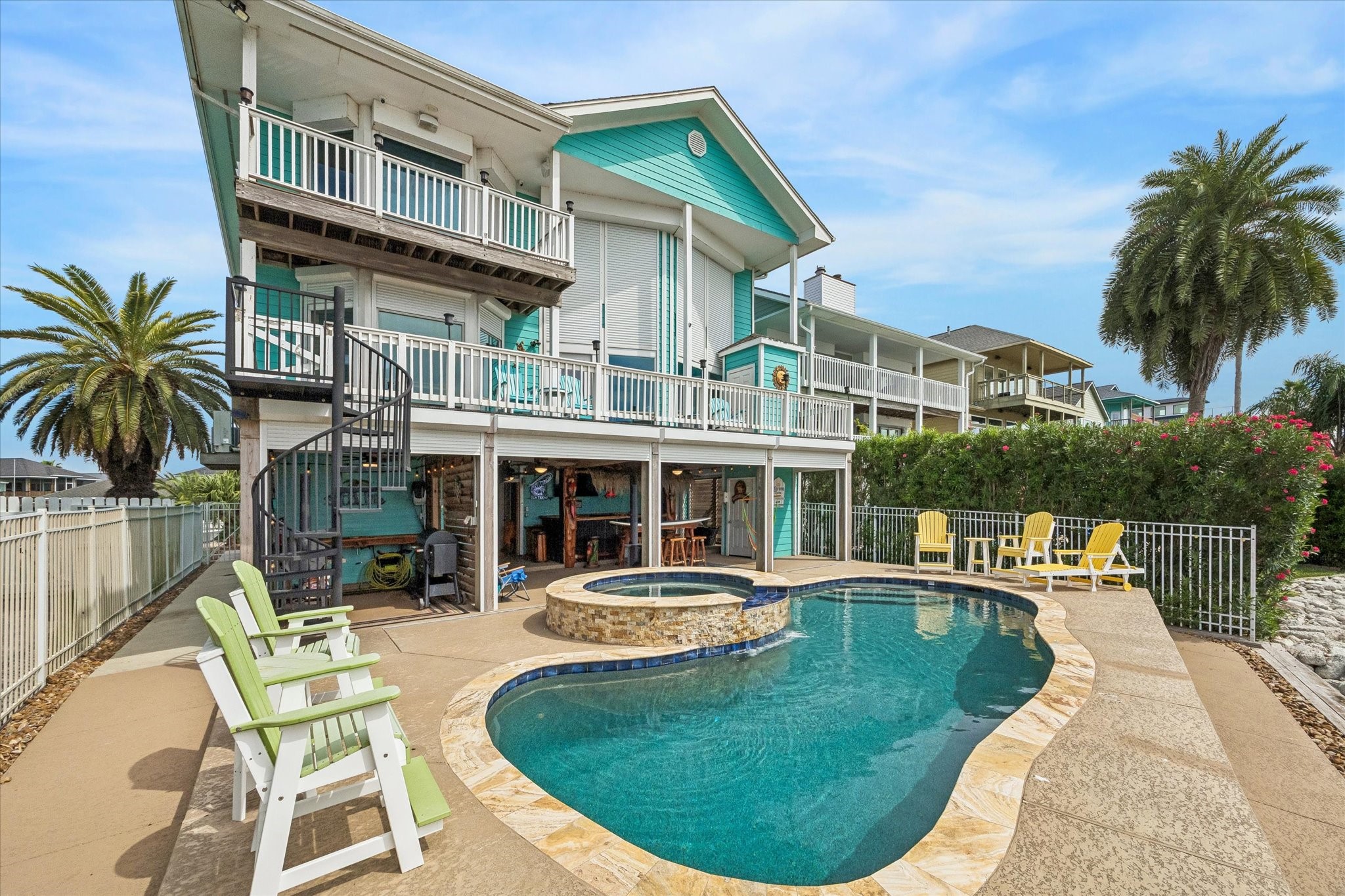 AN ELEVATED VIEW HIGHLIGHTS THE POOL, RAISED SPA, PRIVATE PIER, AND EXPANSIVE OPEN WATER.