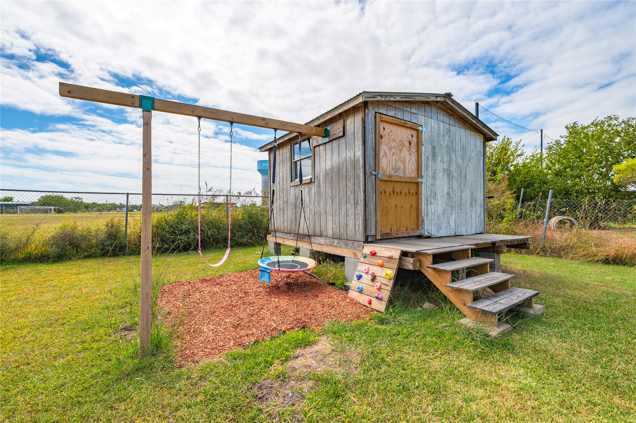 Storage shed and kids swing at the back of the property.