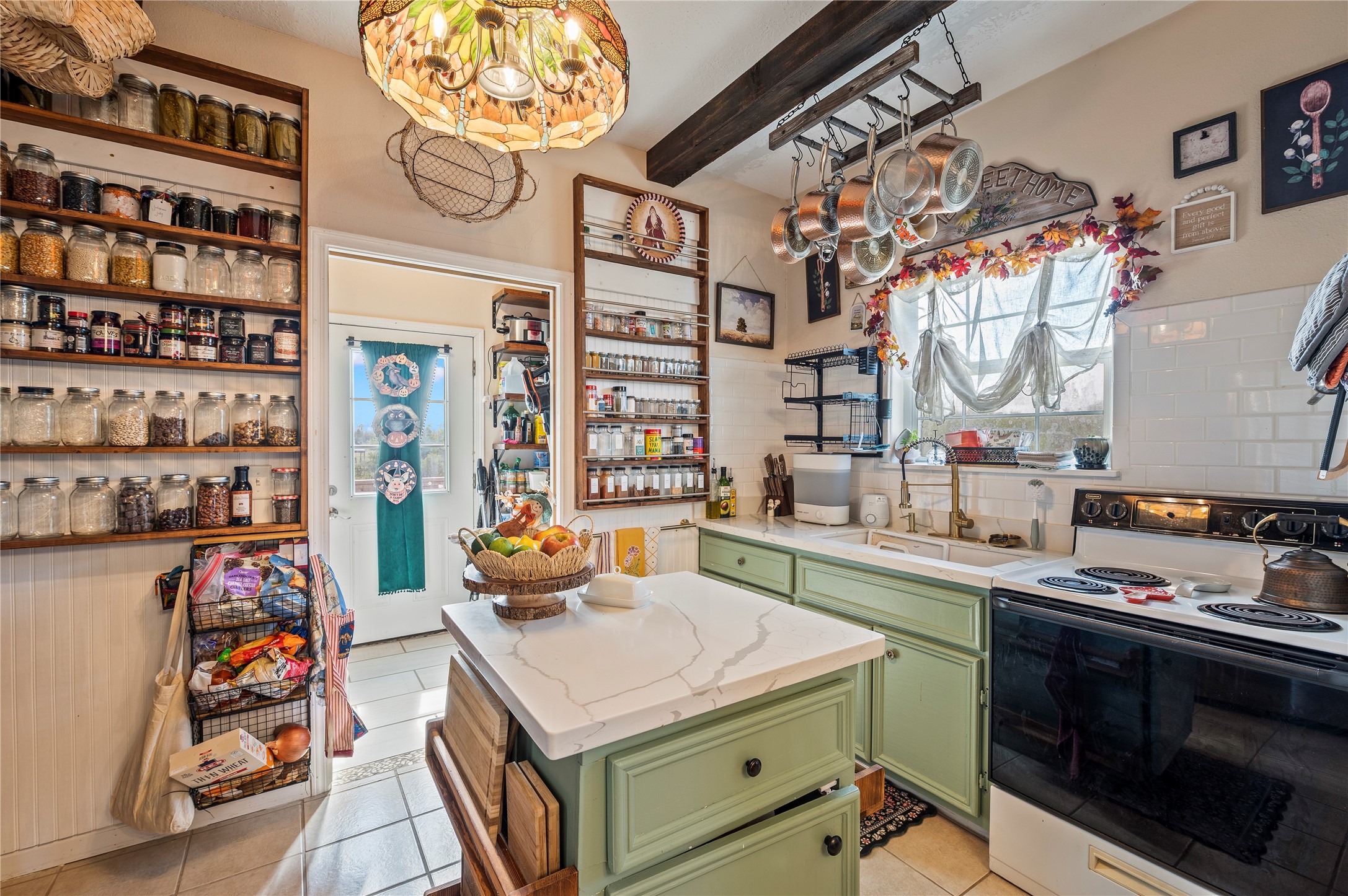 Custom island kitchen with upscale light fixtures, tile flooring, and more custom wall fixtures.