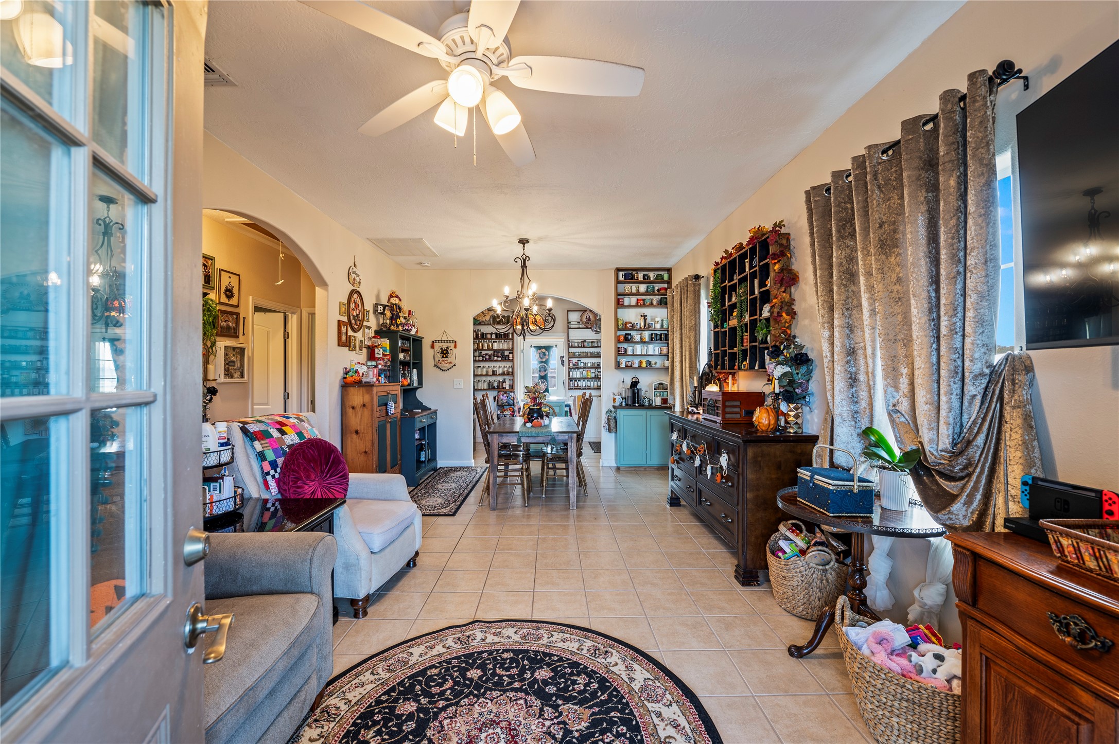 Front door opens up to a tiled, open concept living room/dining room design.