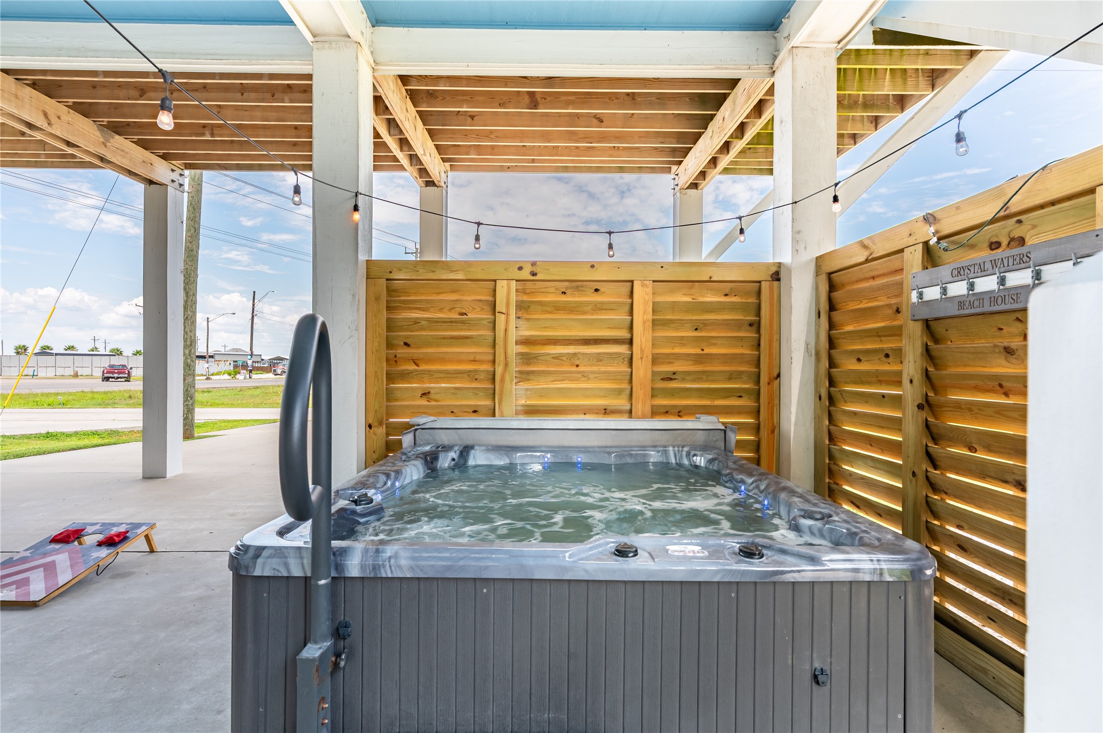 Melt into your private hot tub after a day at the beach, surrounded by privacy screening and twinkling string lights.