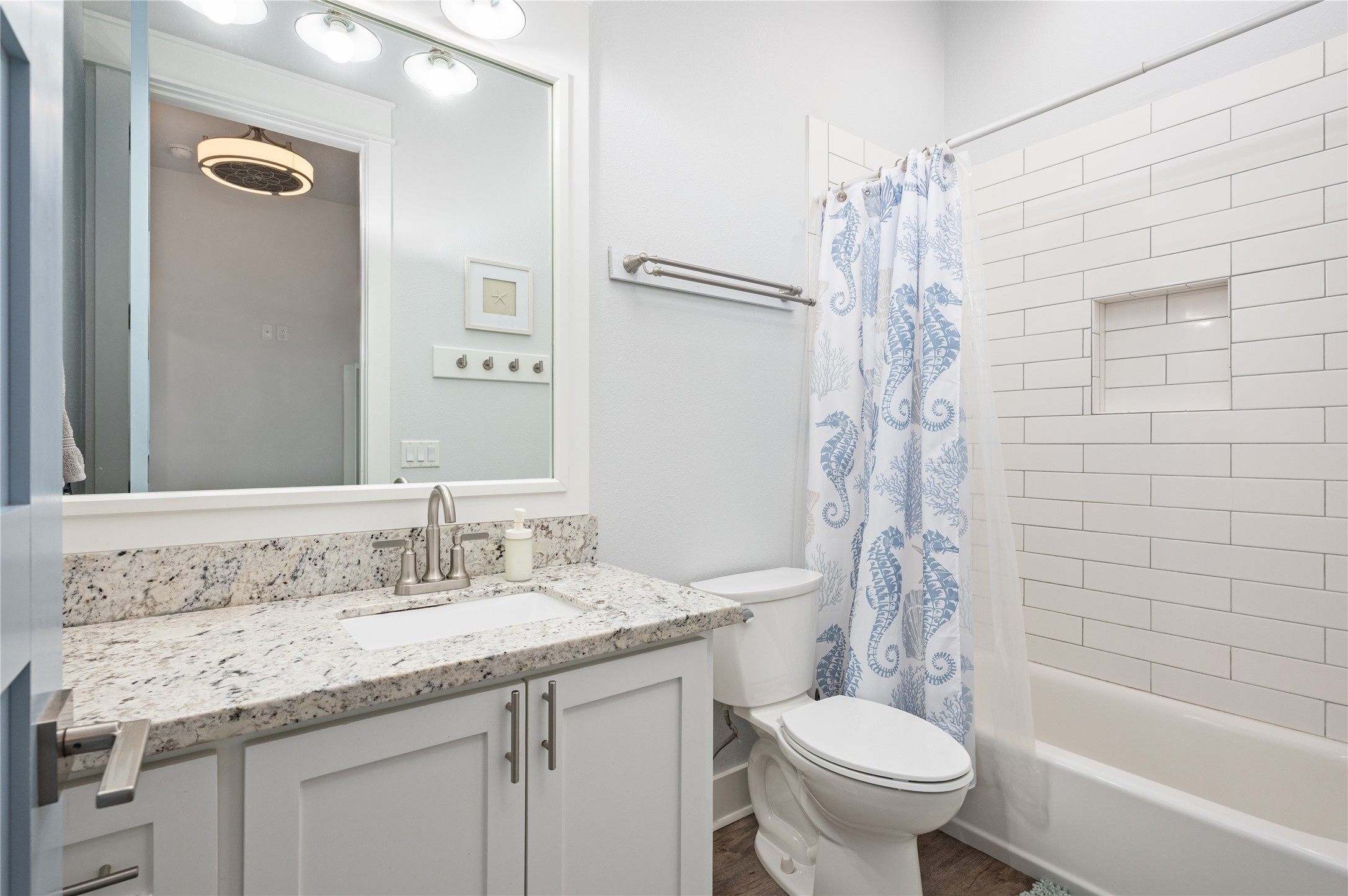 Your full bath pairs a granite-topped vanity with a subway-tile tub and shower surround for a clean, timeless finish.