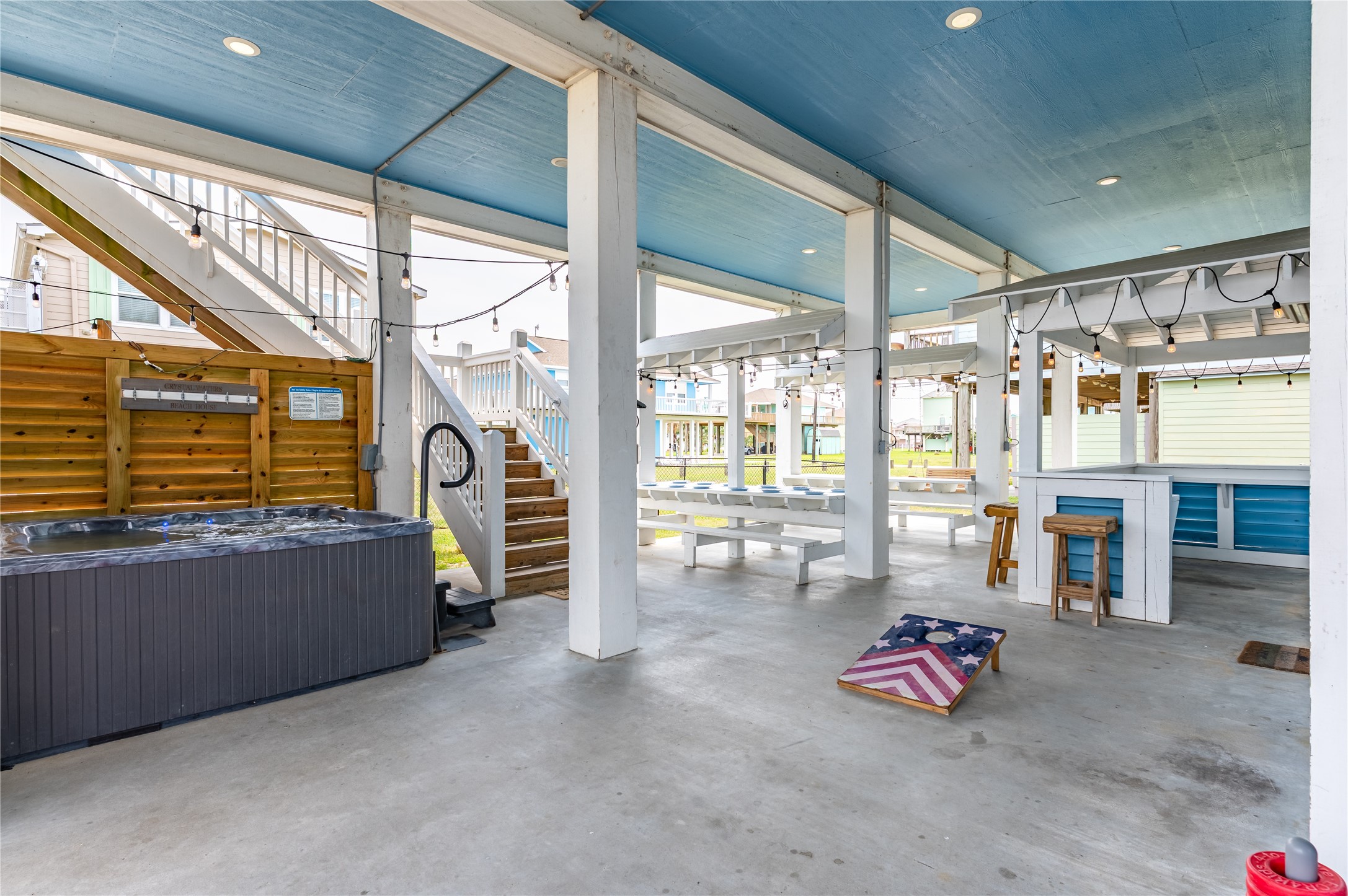 Downstairs is built for fun, with your hot tub, game space, bar seating, and plenty of covered room for everyone to hang out.