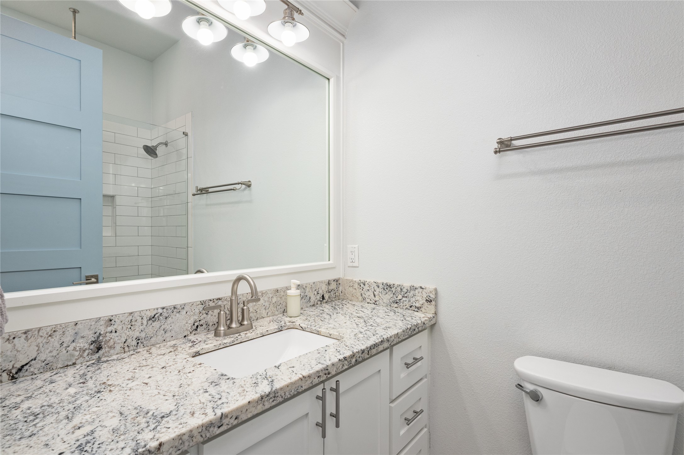 Getting ready is easy in your bright bathroom, featuring a granite-topped vanity, generous mirror, and coordinating subway-tile shower.