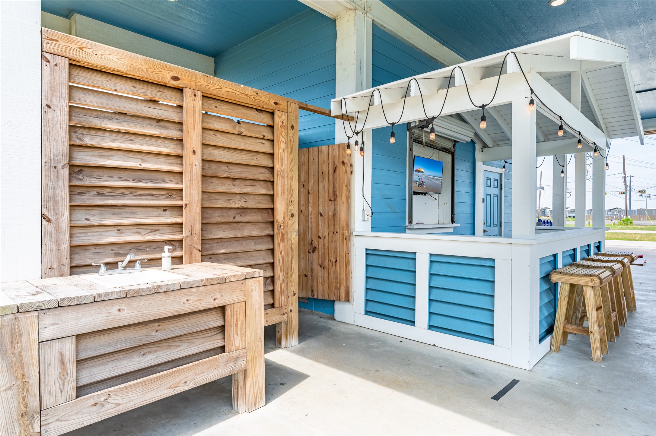 Your outdoor bar keeps the good times flowing with counter seating, string lights, and a convenient sink for easy entertaining.
