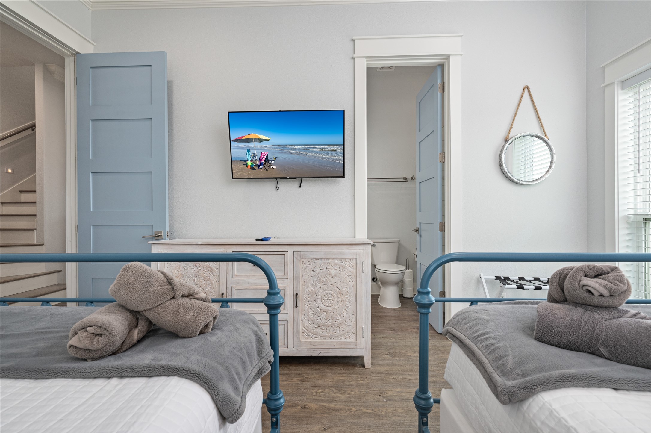 This comfortable guest room keeps everything close at hand with two beds, a wall-mounted TV, and convenient access to the adjoining bath.