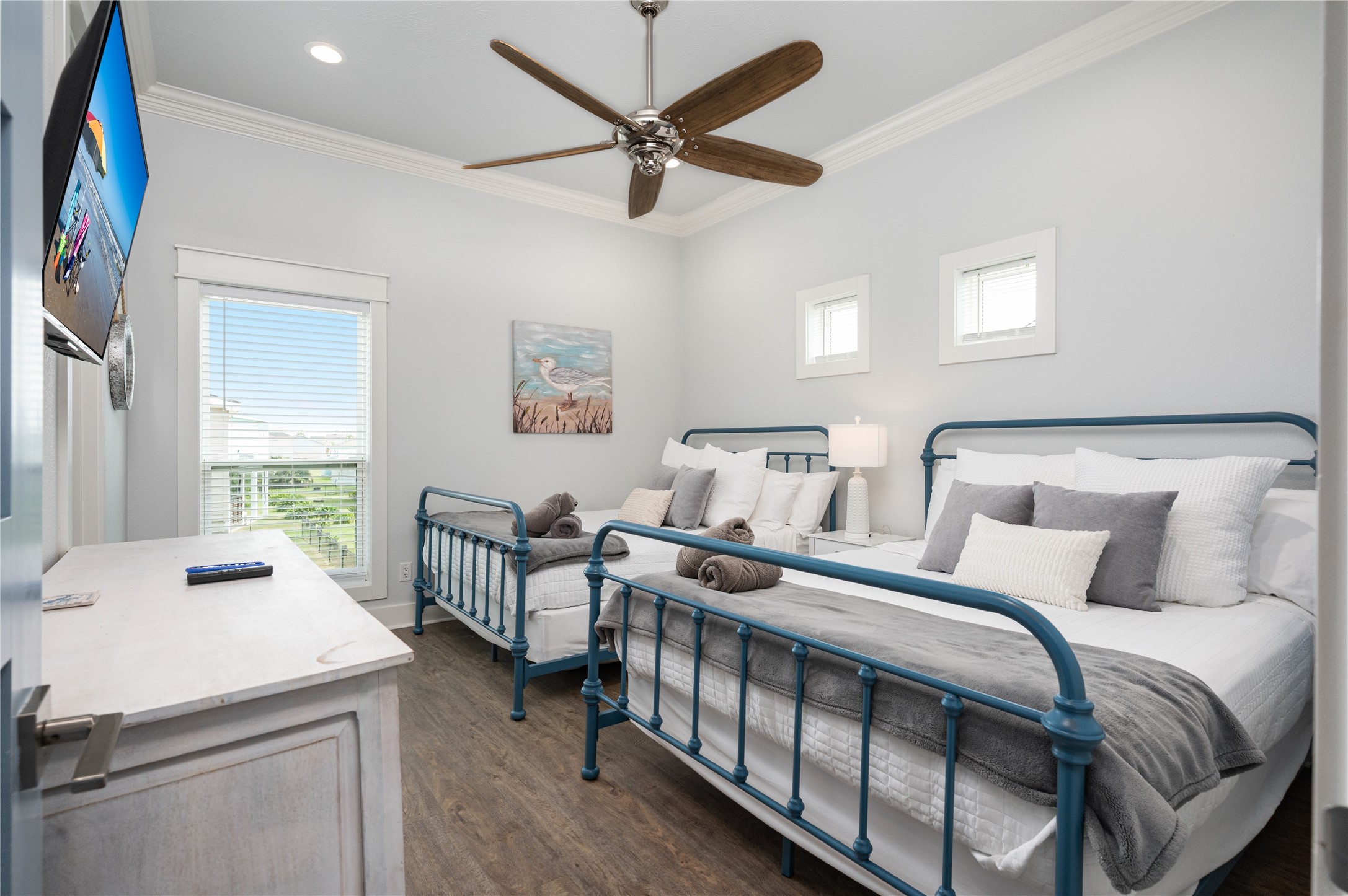 Guests have a comfortable place of their own in this bright bedroom, complete with two beds, a ceiling fan, and plenty of natural light.