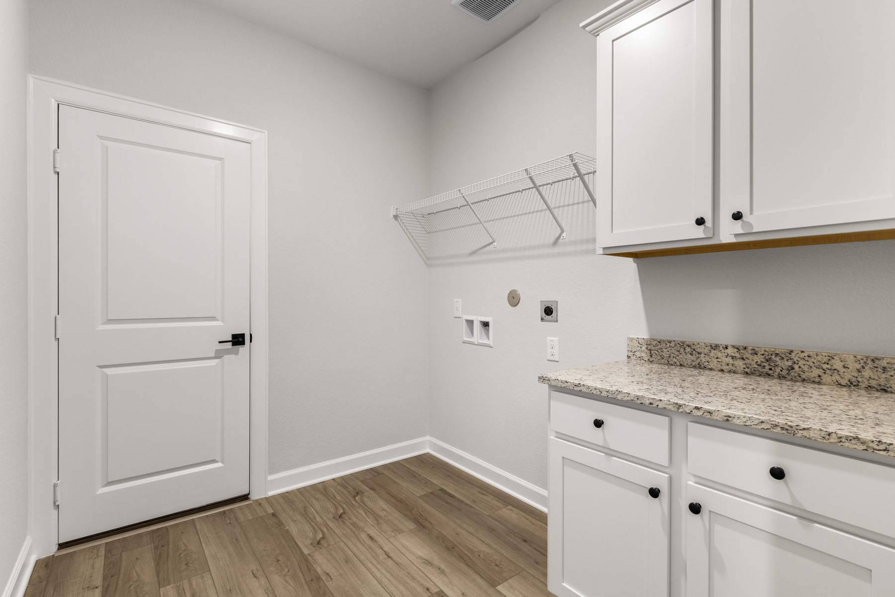 The utility room features storage cabinets and folding station.