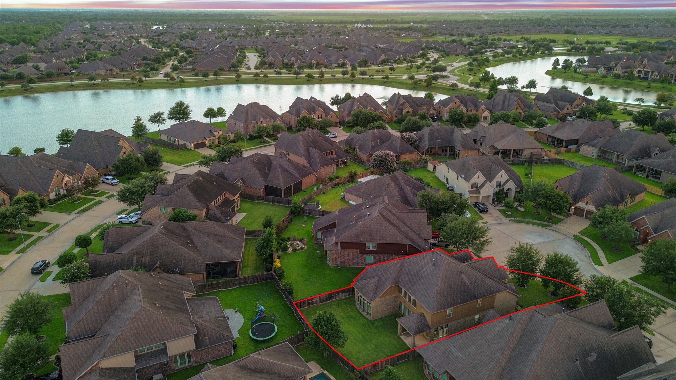 This aerial perspective showcases the home's impressive lot size, private backyard, and exceptional location within the neighborhood, just moments from the scenic lake and walking paths.