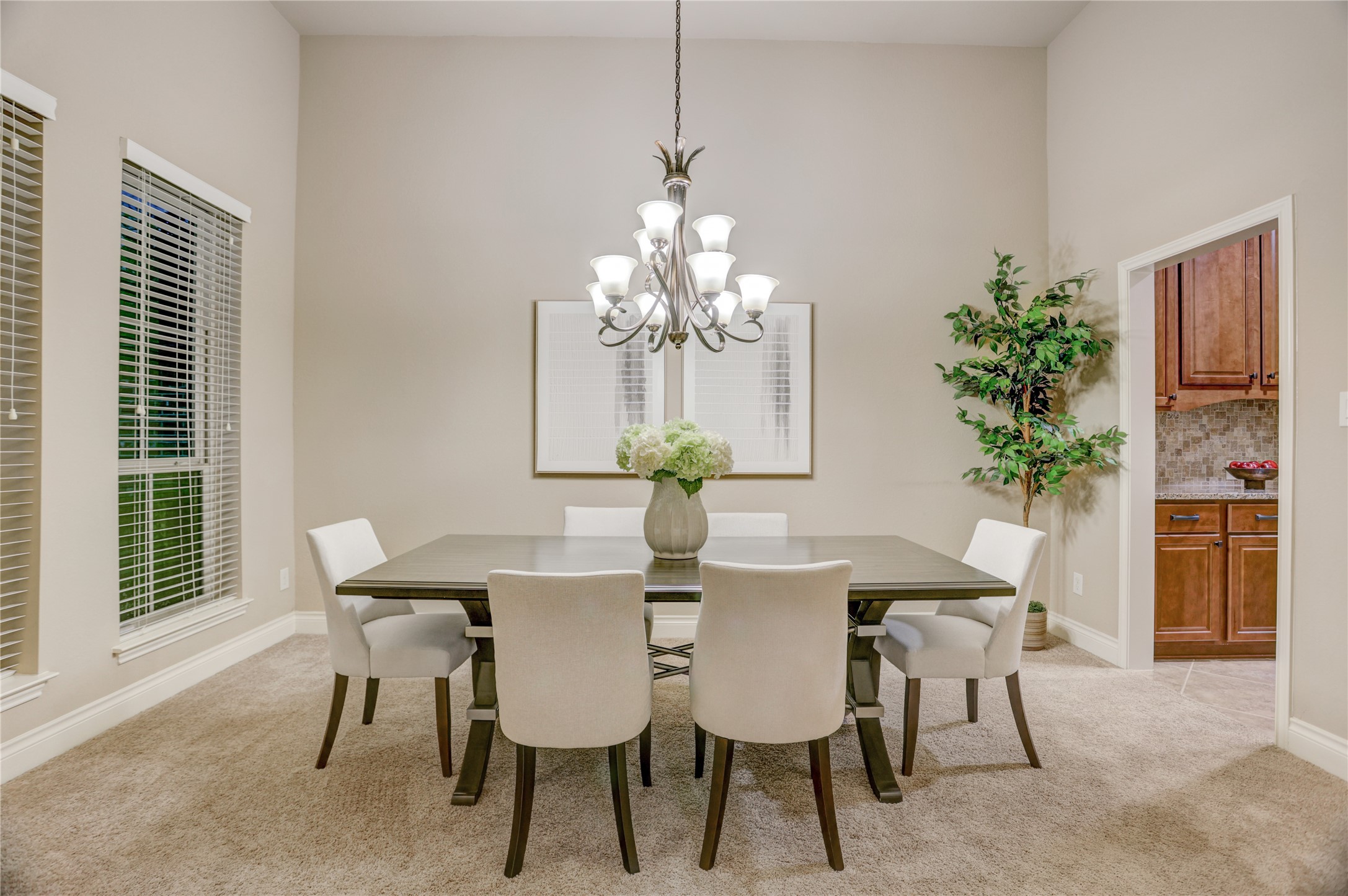 Elegant formal dining room featuring soaring ceilings, abundant natural light, and a stylish chandelier that creates the perfect setting for holiday gatherings, dinner parties, and everyday entertaining. Conveniently located adjacent to the kitchen for seamless hosting.