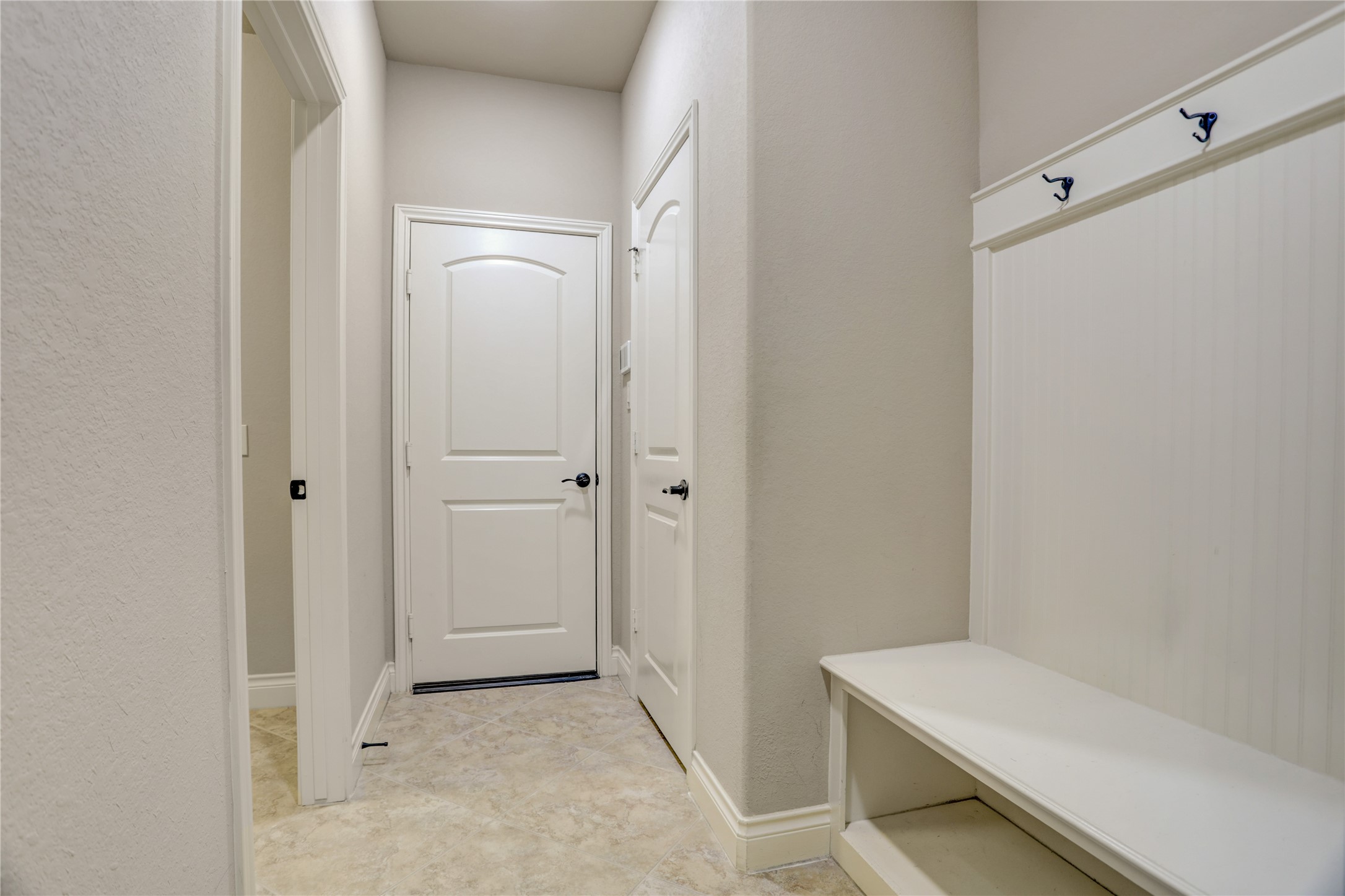 Convenient mudroom located just off the garage, featuring a built-in storage bench and hooks to help keep coats, shoes, backpacks, and everyday essentials organized.