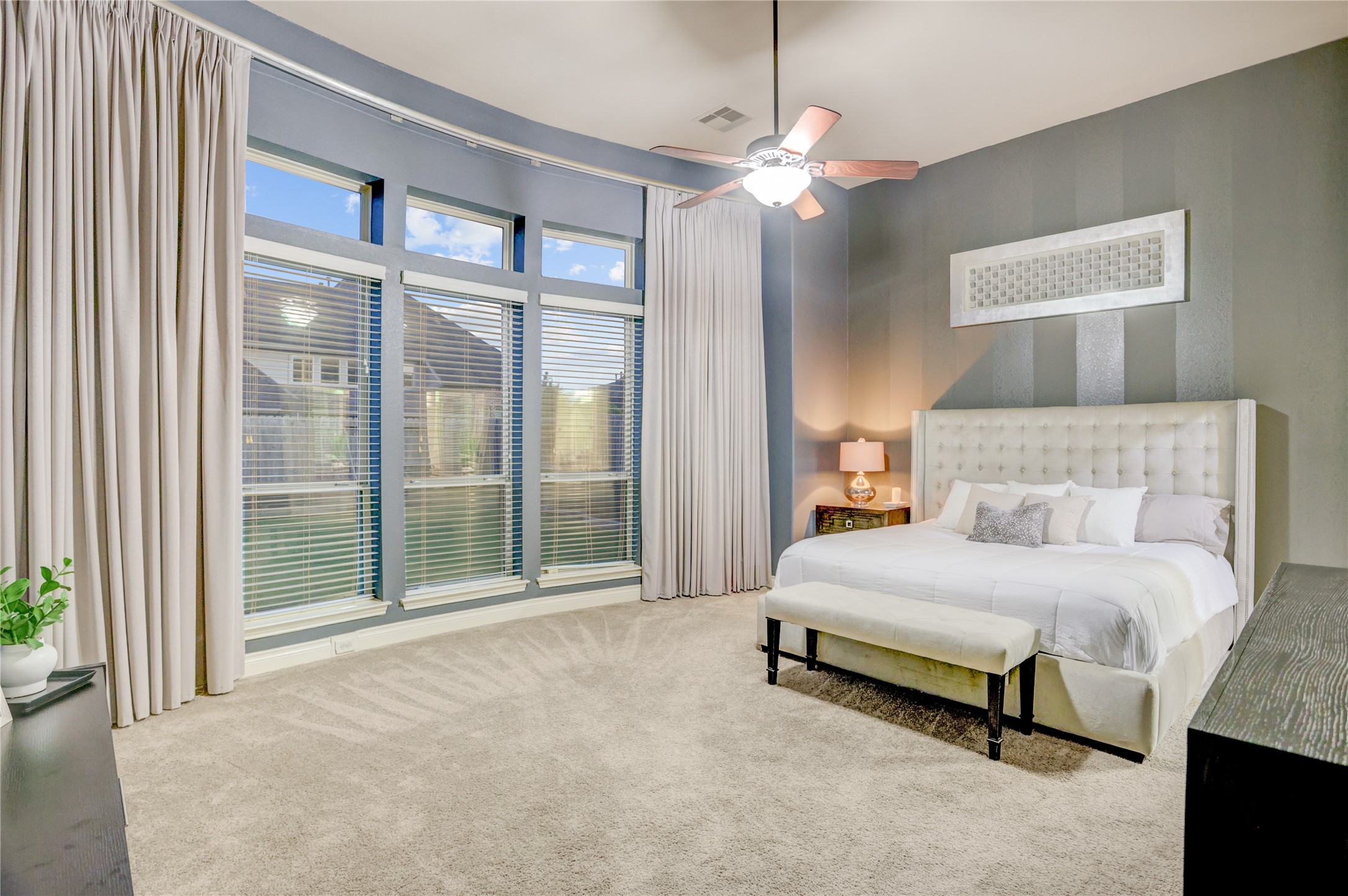 Retreat to the spacious primary suite featuring a stunning curved wall of windows, soaring ceilings, and abundant natural light. This private sanctuary offers generous space for a sitting area while creating a bright, relaxing atmosphere to unwind at the end of the day.