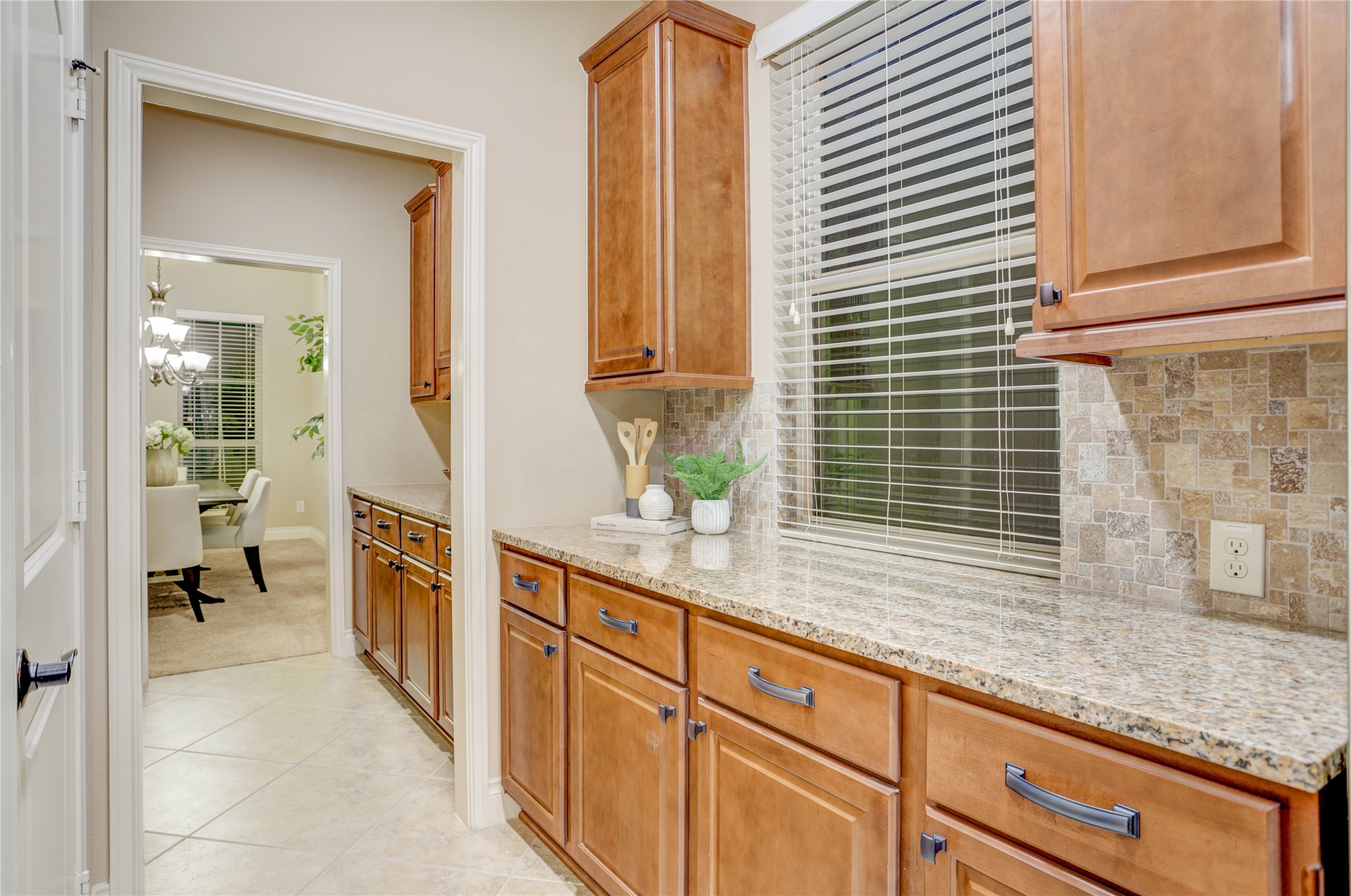 A dedicated butler's pantry with granite countertops, abundant cabinetry, and additional prep space provides the perfect transition between the kitchen and formal dining room. Ideal for serving, entertaining, and extra storage.