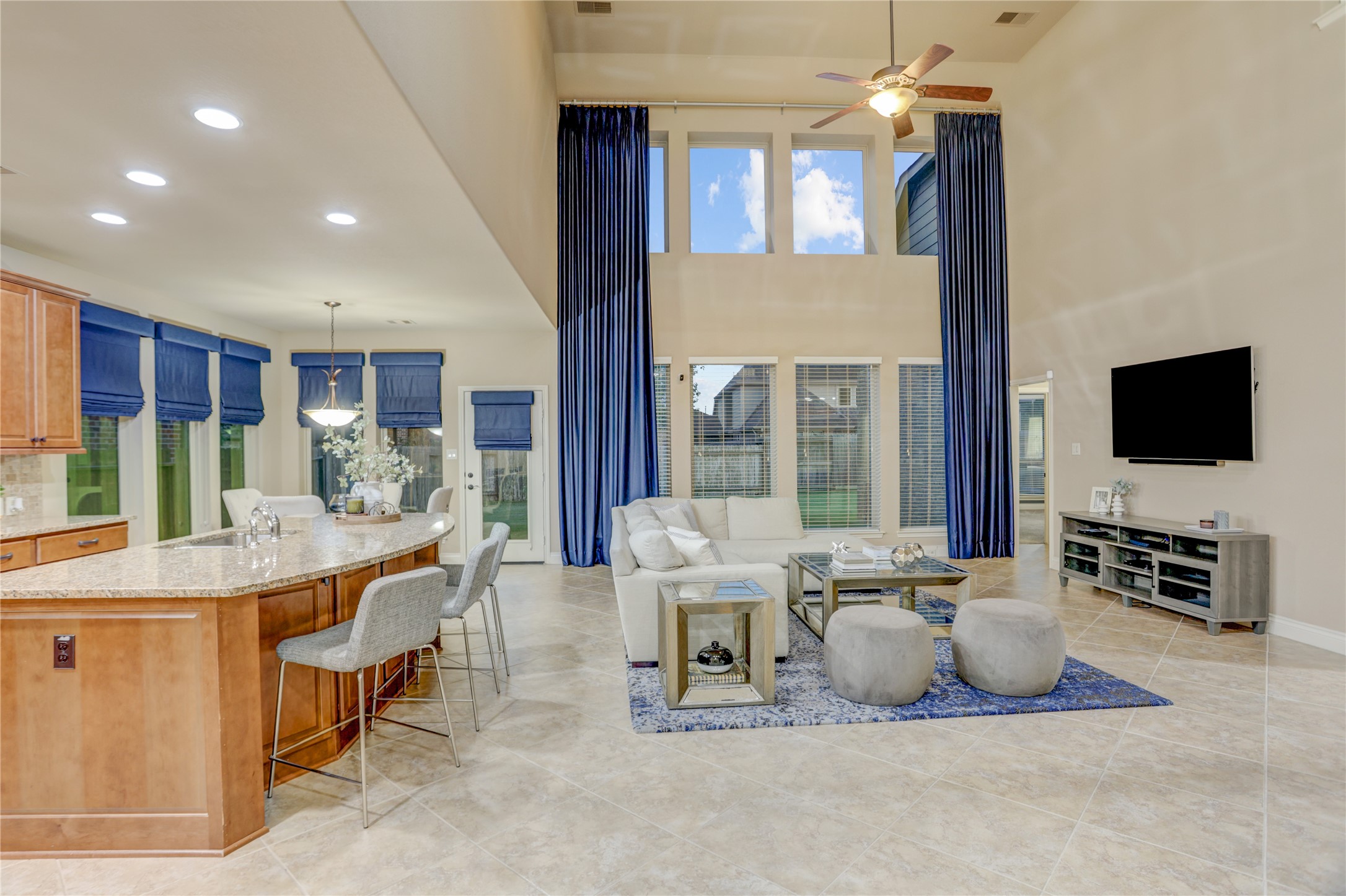 The heart of the home features an open concept design with a dramatic two-story family room, soaring ceilings, expansive windows that flood the space with natural light, and seamless flow into the gourmet kitchen and breakfast area. Perfect for everyday living and effortless entertaining.