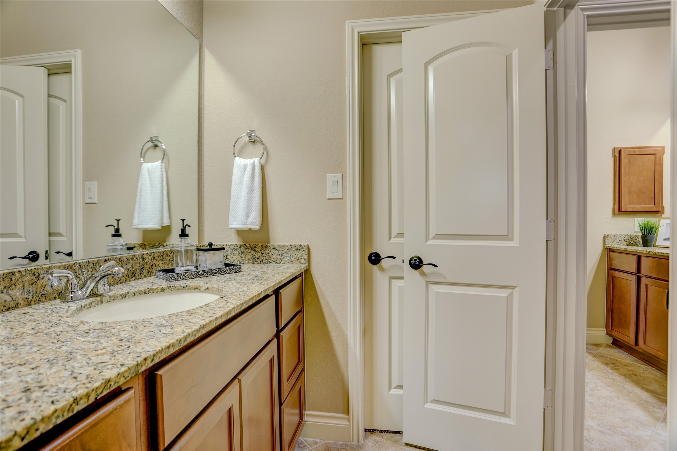 Convenient Jack-and-Jill bathroom featuring a granite vanity, generous counter space, and a functional layout that provides privacy while seamlessly connecting two upstairs bedrooms, perfect for family members or overnight guests.