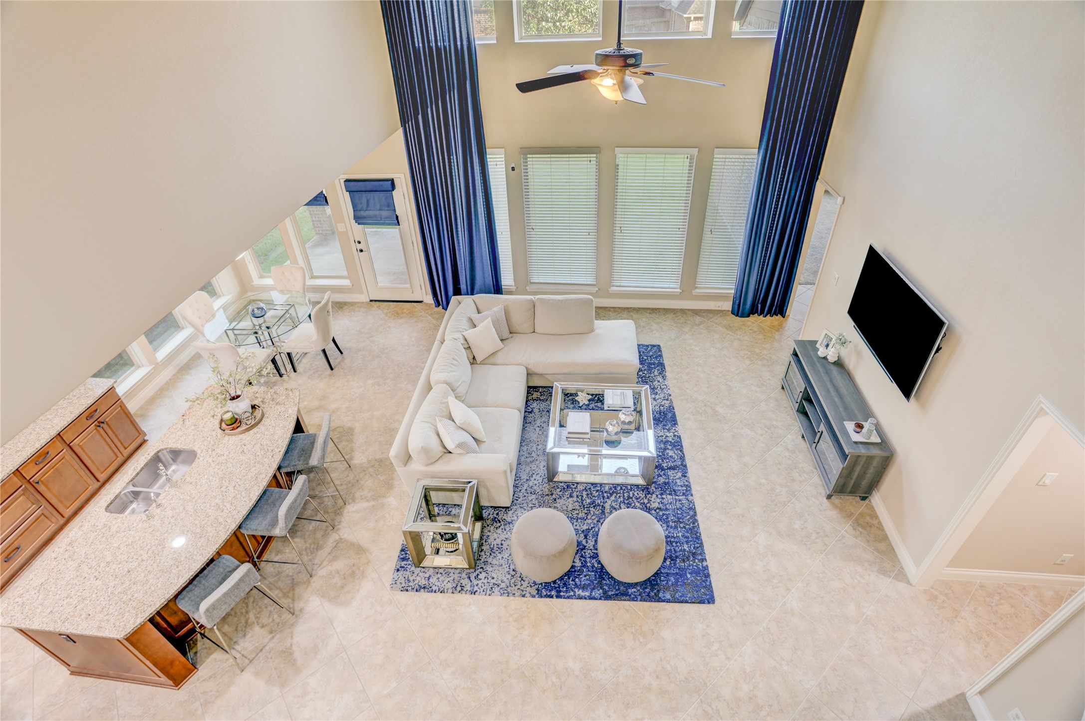 An impressive bird's-eye view showcases the home's dramatic two-story family room, open-concept layout, and seamless flow between the kitchen, breakfast area, and living space. Soaring ceilings and expansive windows fill the home with natural light, creating an inviting atmosphere for everyday living and entertaining.