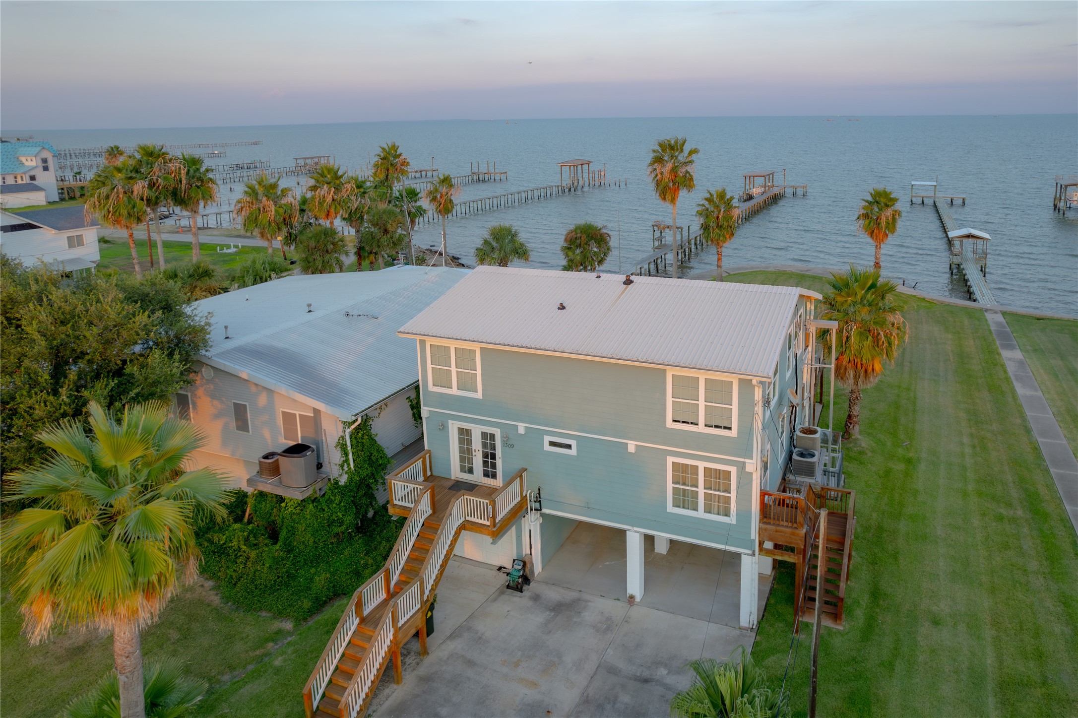 Sunrises & Serenity on the San Leon Bayfront"! As the sun rises over the bay in San Leon, this beautiful home takes on a warm golden glow, its balconies and wide windows perfectly framing the shimmering water.As dusk settles over the water, the sky transforms into a canvas of soft pinks, oranges, and purples, reflecting gently on the calm bay below.