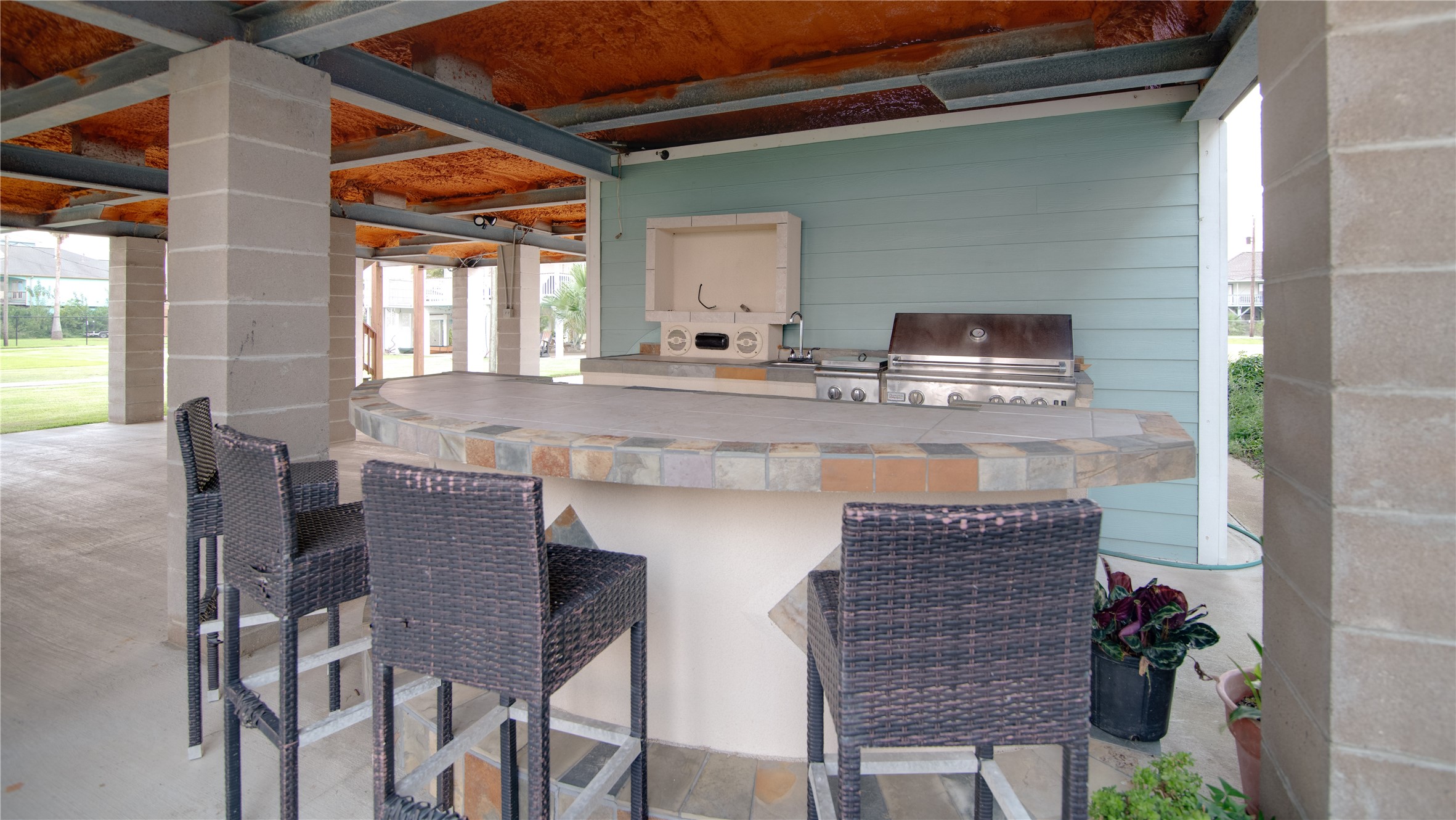 This outdoor kitchen is a stylish and functional space designed for entertaining and alfresco dining. Equipped with a built-in grill, ample counter space, and storage for utensils and supplies, it makes cooking outdoors effortless. The area is complemented by durable surfaces and thoughtful layout, allowing guests to mingle while meals are prepared, all while enjoying the fresh air and scenic views of the bay.