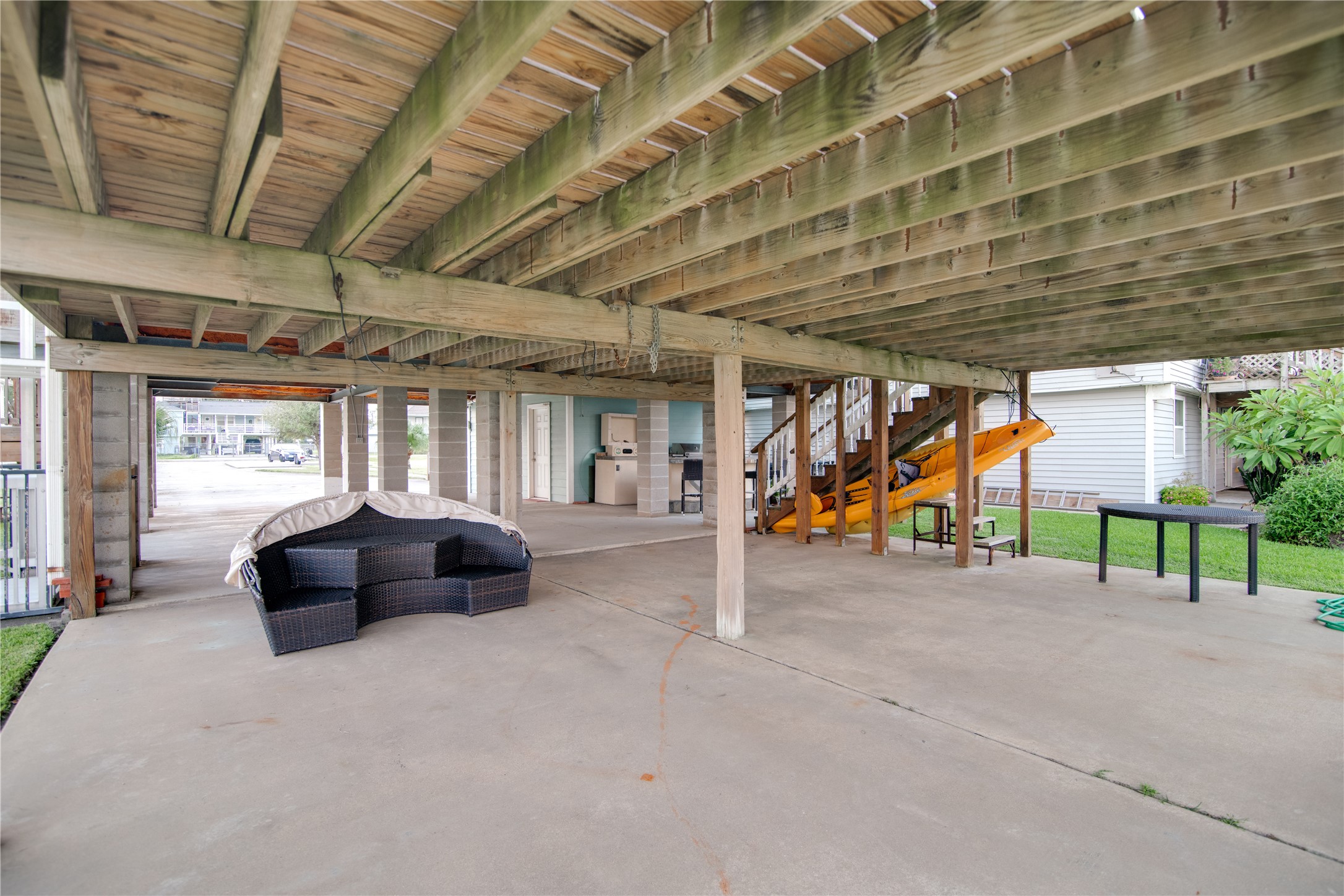 Beneath this stilted home, a spacious covered area provides the perfect spot for outdoor entertainment and relaxation. The open-air space is sheltered from the elements, making it ideal for dining, gatherings, or simply enjoying the coastal breeze. With plenty of room for seating, parking, or recreational activities, it combines functionality with casual charm, extending the living space while taking full advantage of the waterfront setting.