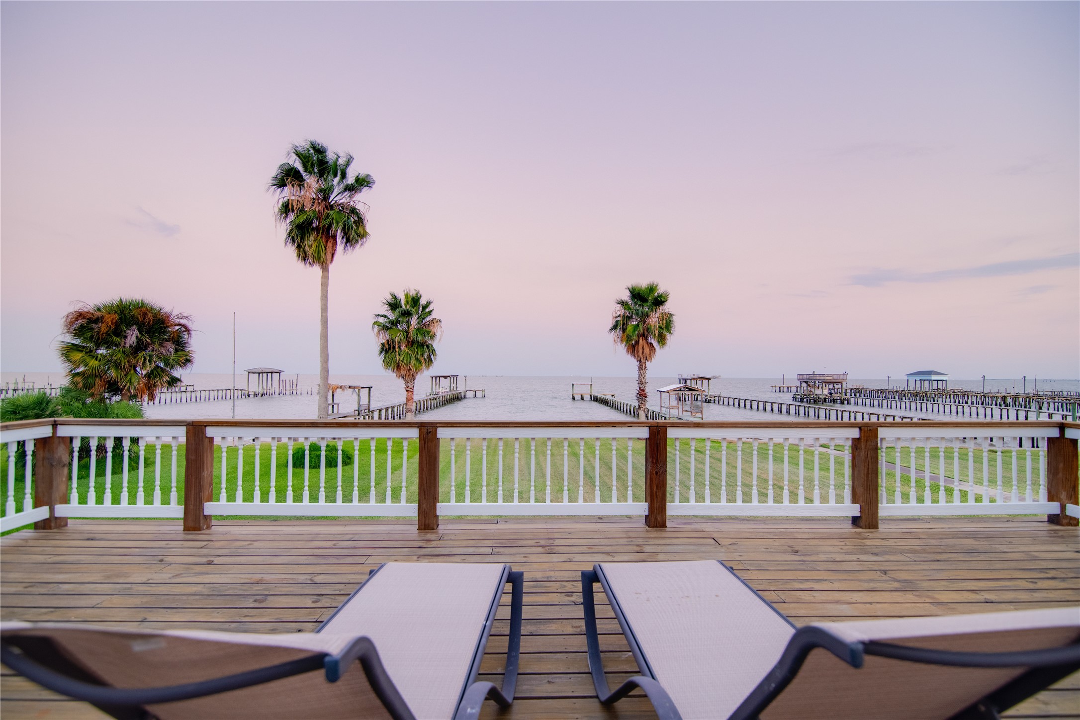 From the comfort of lounge chairs on the deck, the bay unfolds in a picturesque panorama. Sailboats glide gracefully across the water, cargo ships pass in the distance, and seabirds circle overhead, adding life and movement to the serene scene.