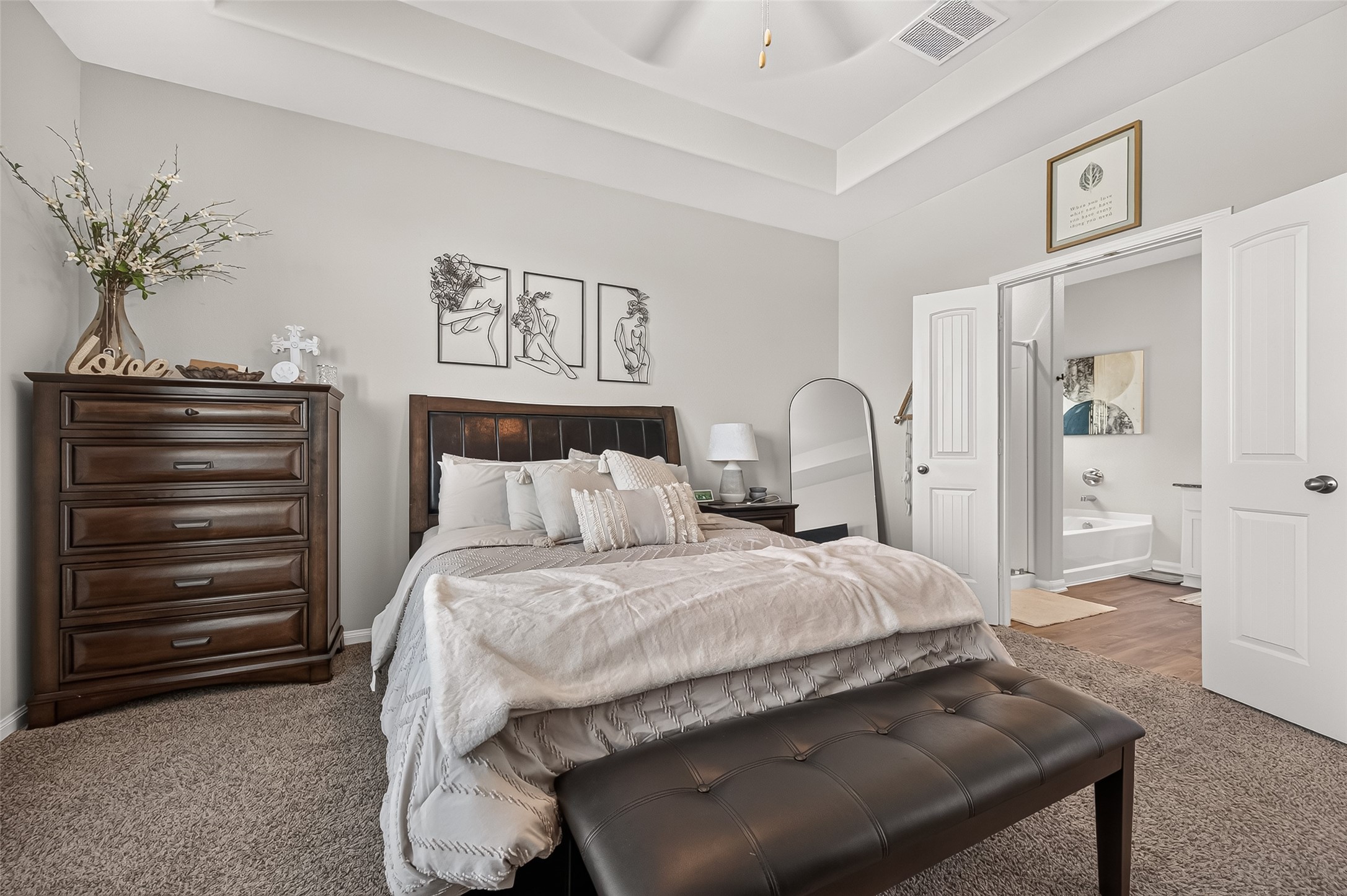 Elegant bedroom with a cozy bed, chic decor, and an ensuite bathroom, perfect for relaxation and comfort.