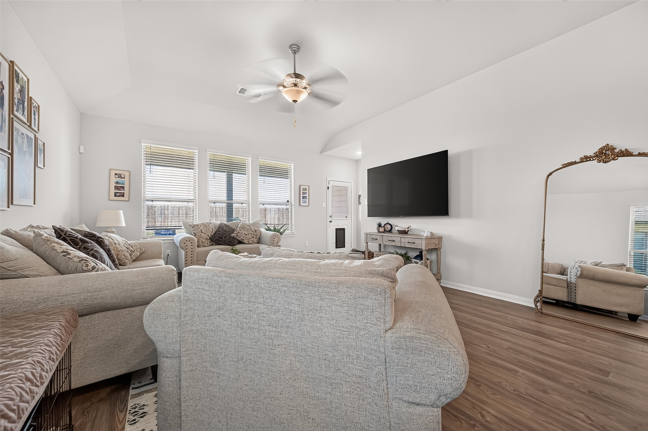 Spacious living room with abundant natural light, elegant hardwood floors, and a cozy seating area perfect for relaxation.