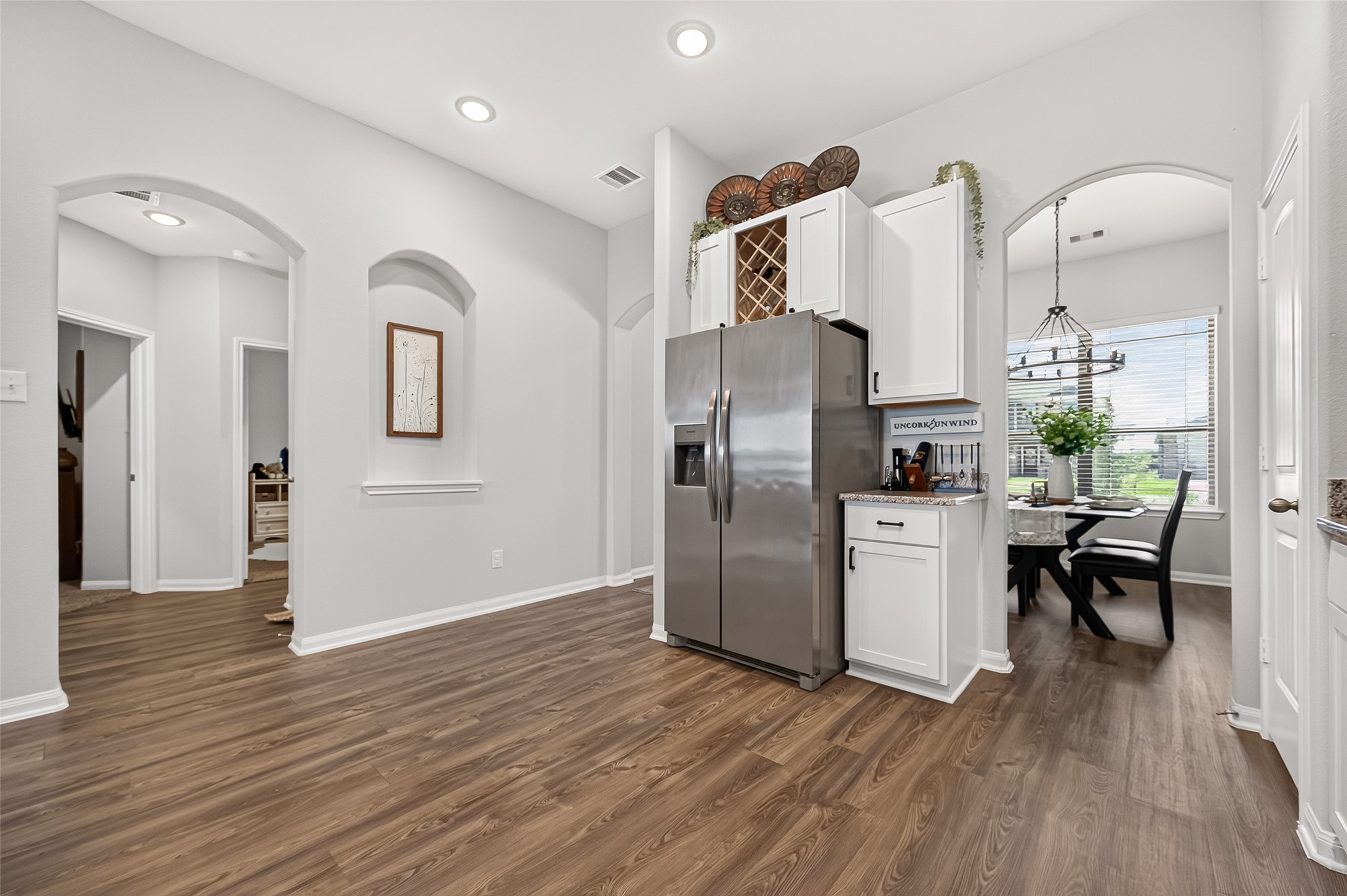 Modern kitchen with sleek stainless steel appliances, elegant cabinetry, and a charming dining area bathed in natural light.