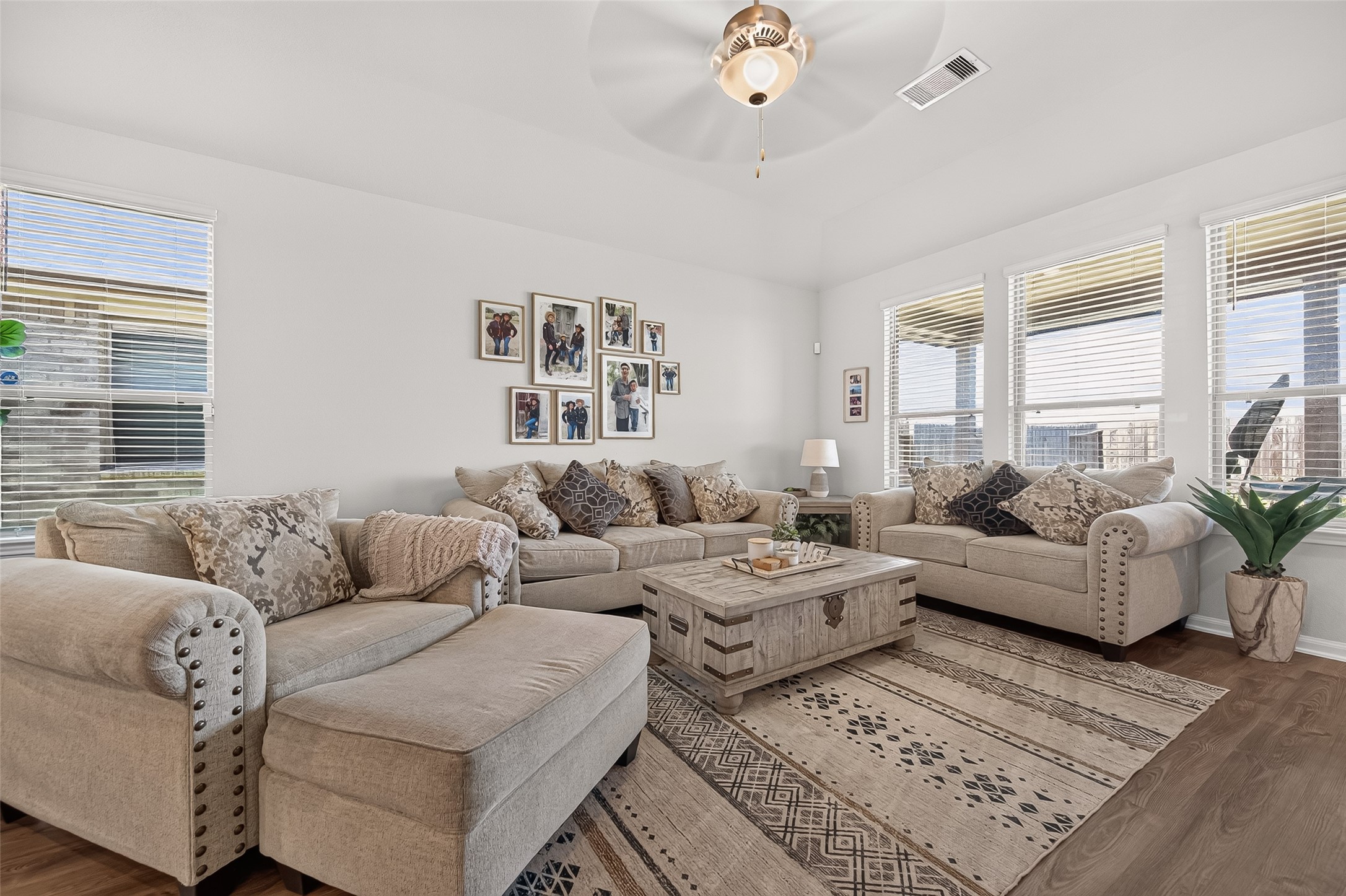 Bright and inviting living room with plush seating, a stylish coffee table, and abundant natural light streaming through multiple windows, perfect for relaxation and entertaining.