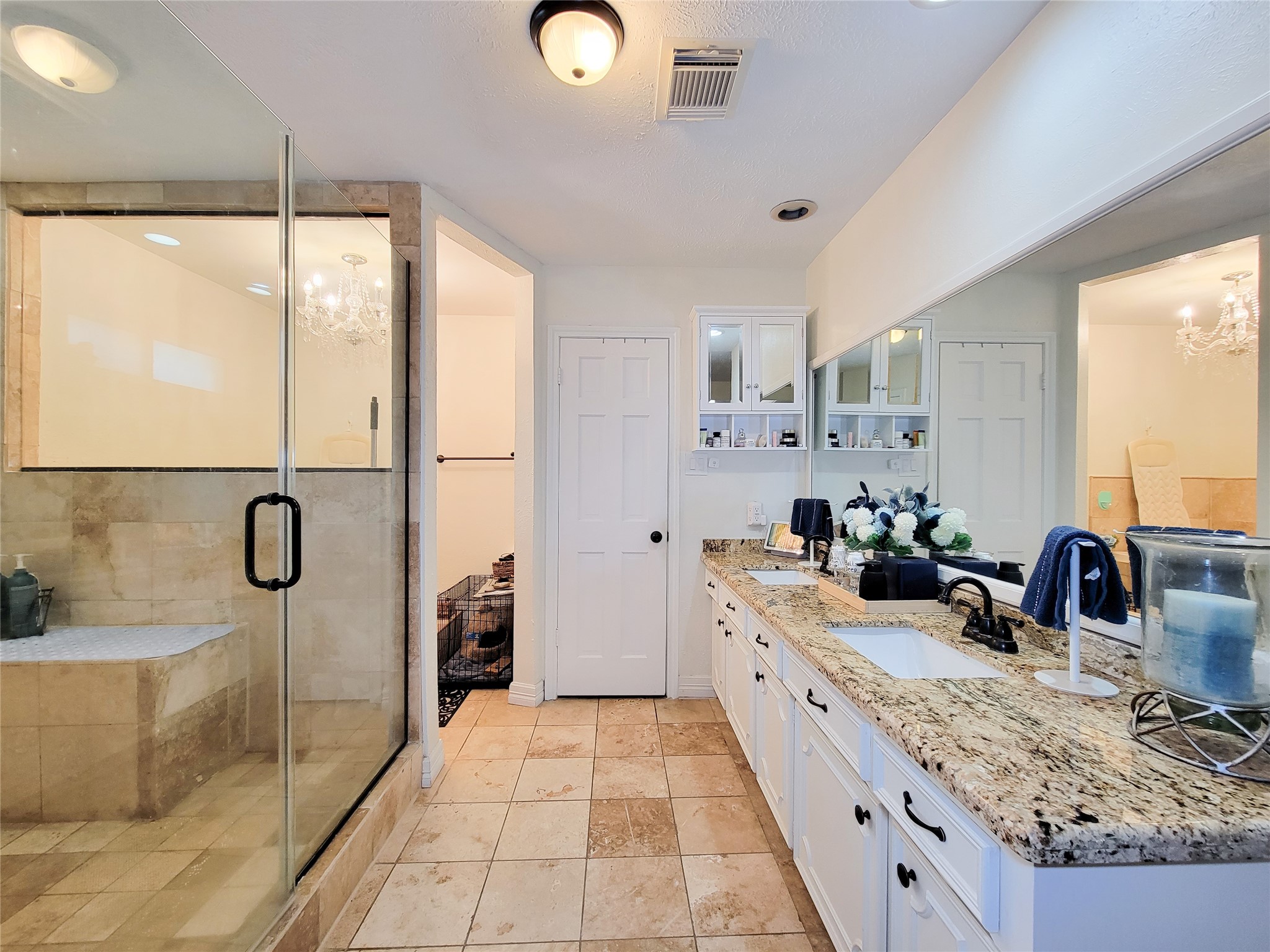 This spacious bathroom features a large glass-enclosed shower with elegant tilework, a double-sink vanity with granite countertops, ample cabinet storage, and a bright, inviting atmosphere. This spacious bathroom features a large glass-enclosed shower with elegant tilework, a double-sink vanity with granite countertops, ample cabinet storage, and a bright, inviting atmosphere.