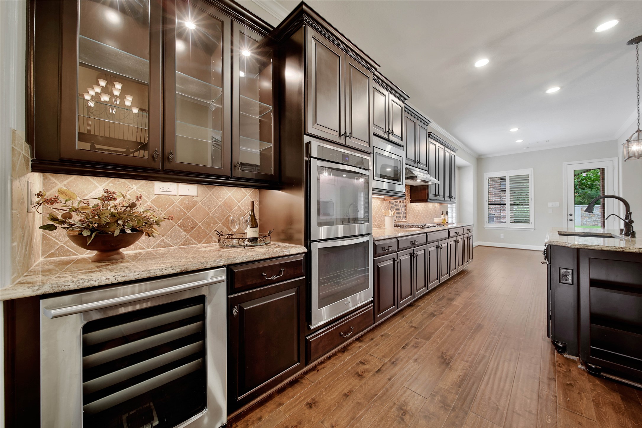The butlers pantry adds both style and function with glass-front upper cabinets perfect for displaying stemware, along with a built-in beverage cooler for effortless entertaining.