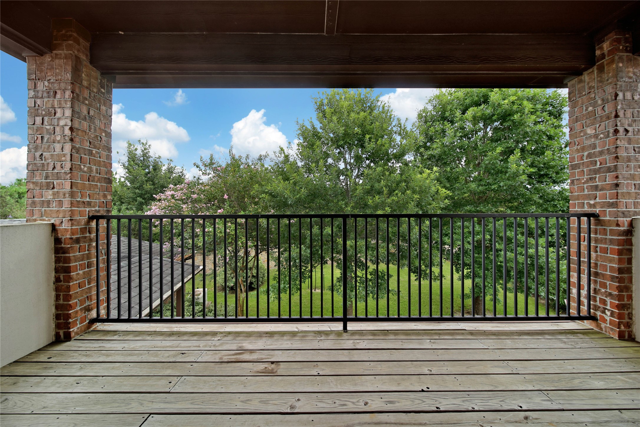 The upper balcony overlooks the backyard, offering a peaceful spot to enjoy the view and take in the outdoor surroundings.