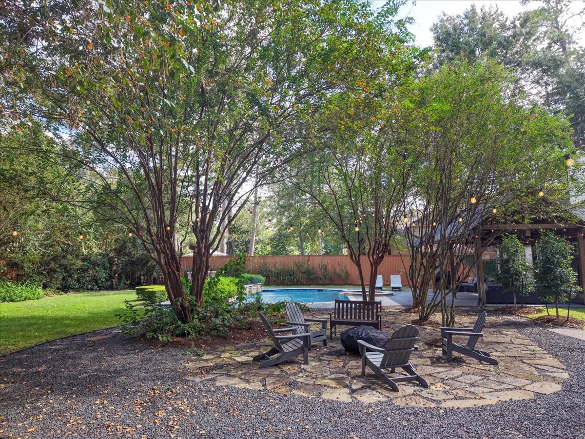 This flagstone fire pit seating area is tucked among the trees, a peaceful spot for cool nights with family and friends, with a mosquito system (2024) keeping the evenings comfortable.