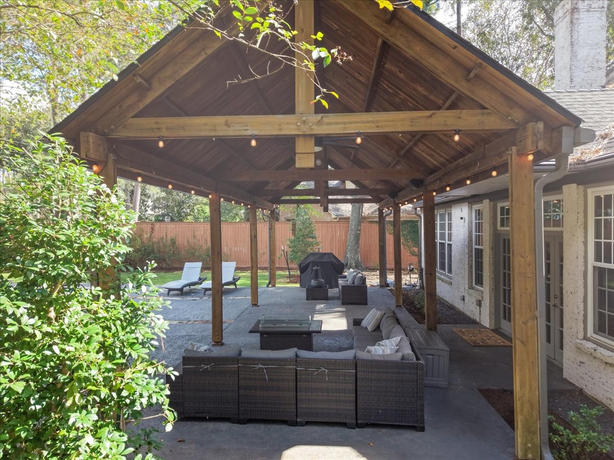 Step through the French doors onto this oversized covered patio, where cedar beams and warm string lights set the scene for morning coffee, game days, and long, easy evenings.