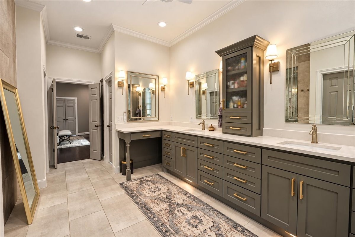 Start your day in style! This primary bath was fully refreshed with new tile flooring and redone cabinetry, finished with gold hardware and a double vanity that gives you generous counter space and storage on both sides. Automatic shades with remote for light and privacy at the touch of a button.