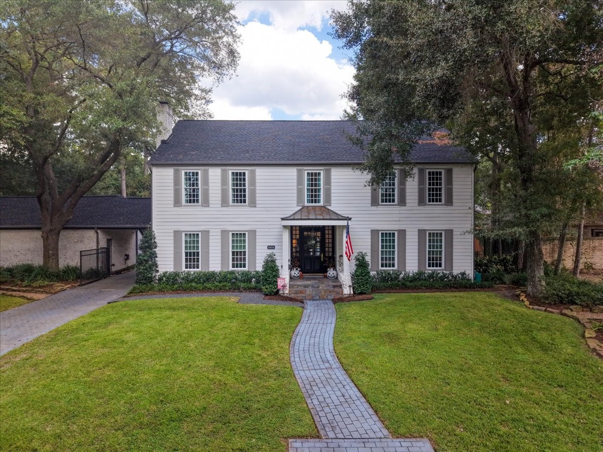 Mature oaks, a manicured lawn, and landscape lighting frame a stately entry in an exclusive, gated neighborhood, with more than $400K in upgrades already done and ready for its next owner.