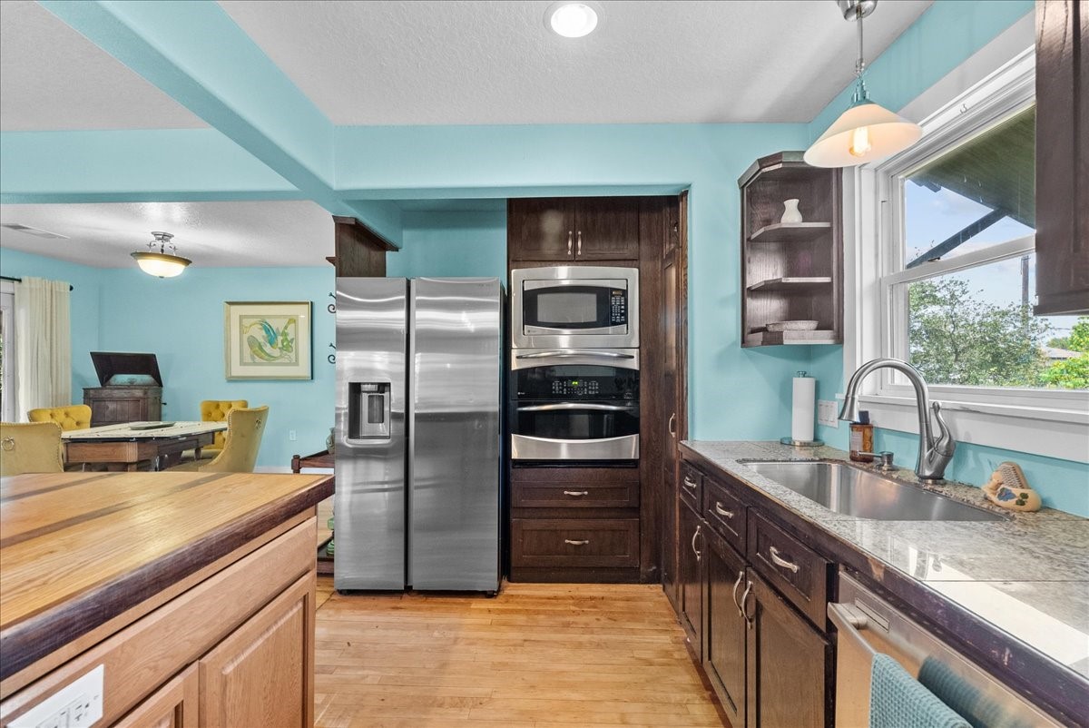 Kitchen features granite countertops, stainless steel appliances, generous cabinetry and a window above the sink bringing in natural light