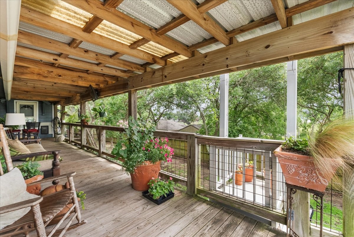 Expansive covered deck provides a shaded outdoor living space surrounded by mature trees that's ideal for relaxing, dining or entertaining