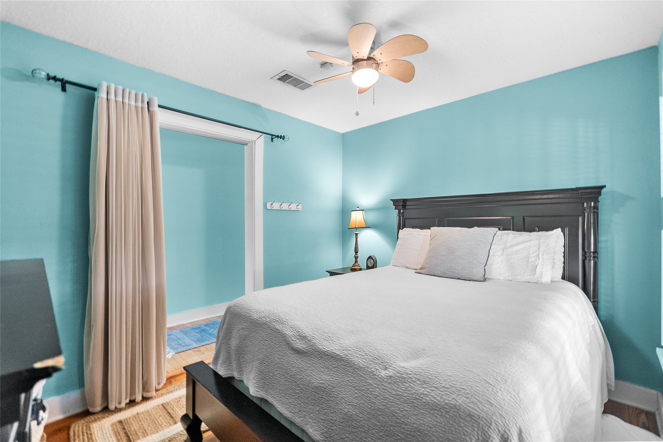 Comfortable secondary bedroom with hardwood flooring and an adjacent bonus area that offers additional flexibility