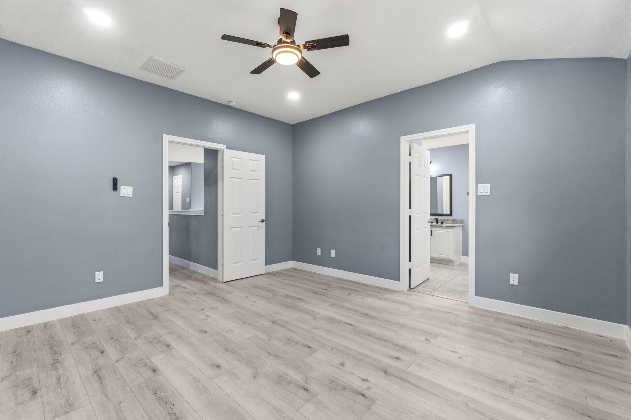Primary Suite features recessed lighting, fans and laminate wood floors