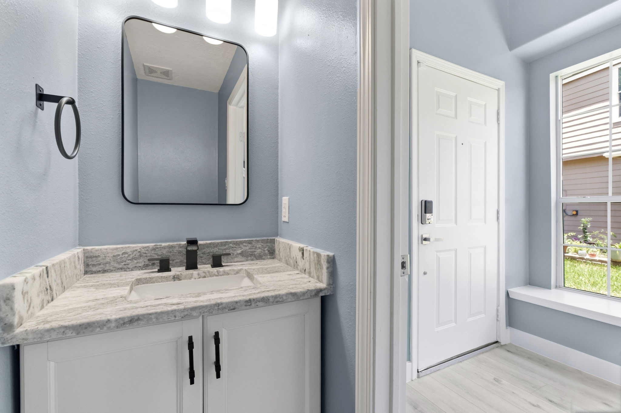Powder Room features granite countertops, designer mirrors, light fixtures, and elongated commode