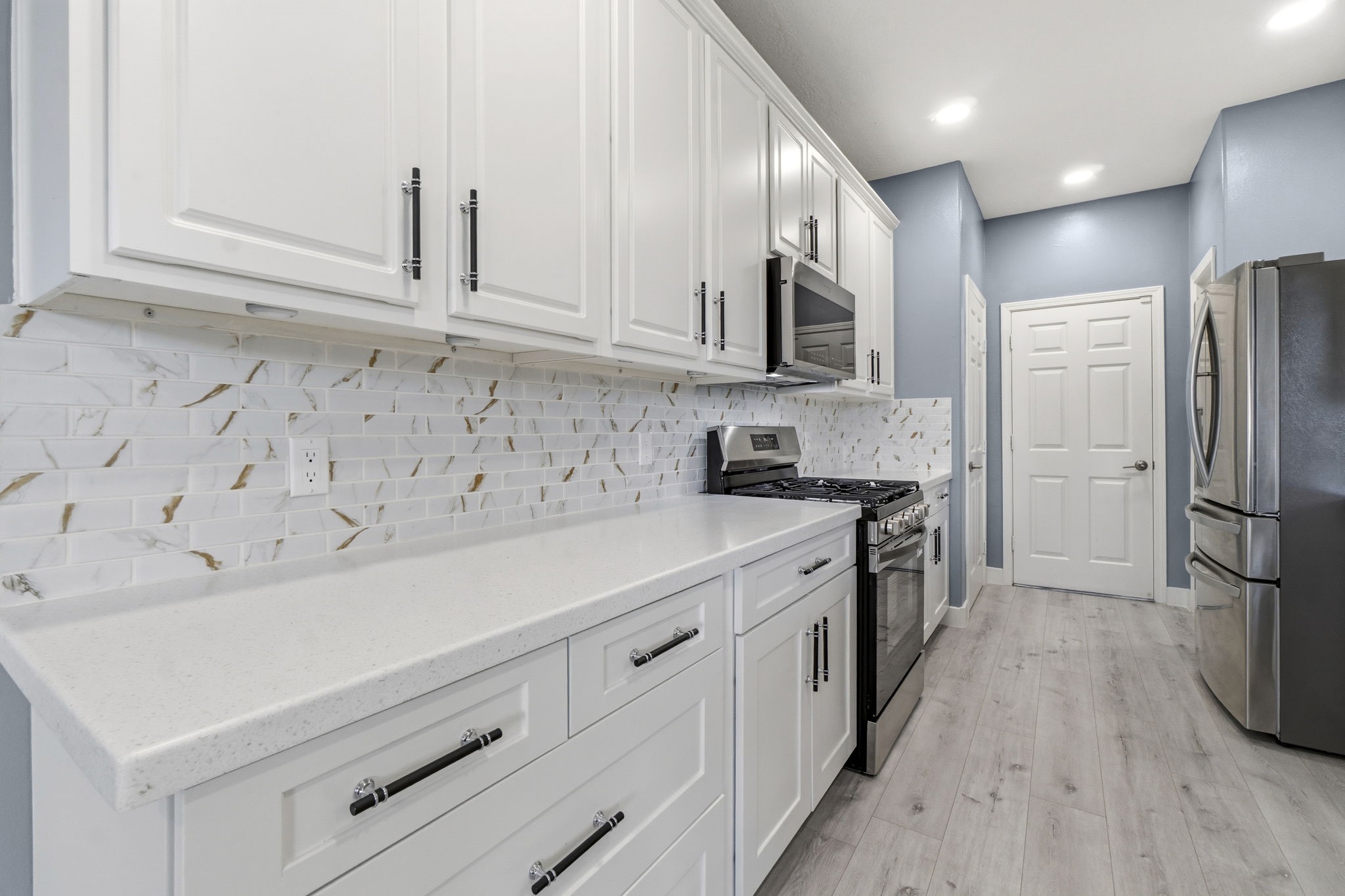 Quartz countertops, oversized cabinets, subway tile backsplash add a modern aesthetic feel.