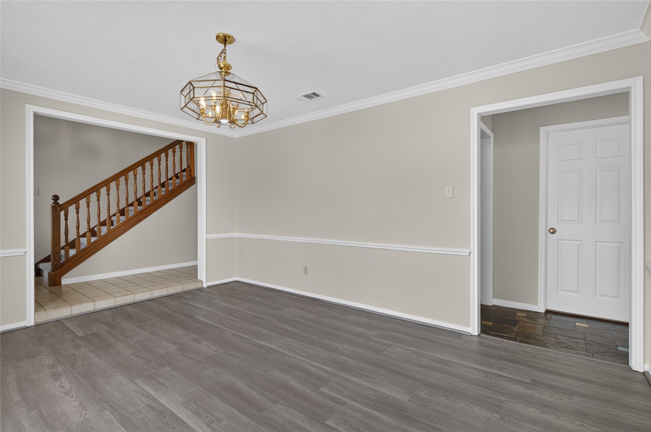 Classic wainscoting, attractive flooring, and a graceful staircase add character to this spacious area while creating an easy flow between the home's living spaces.
