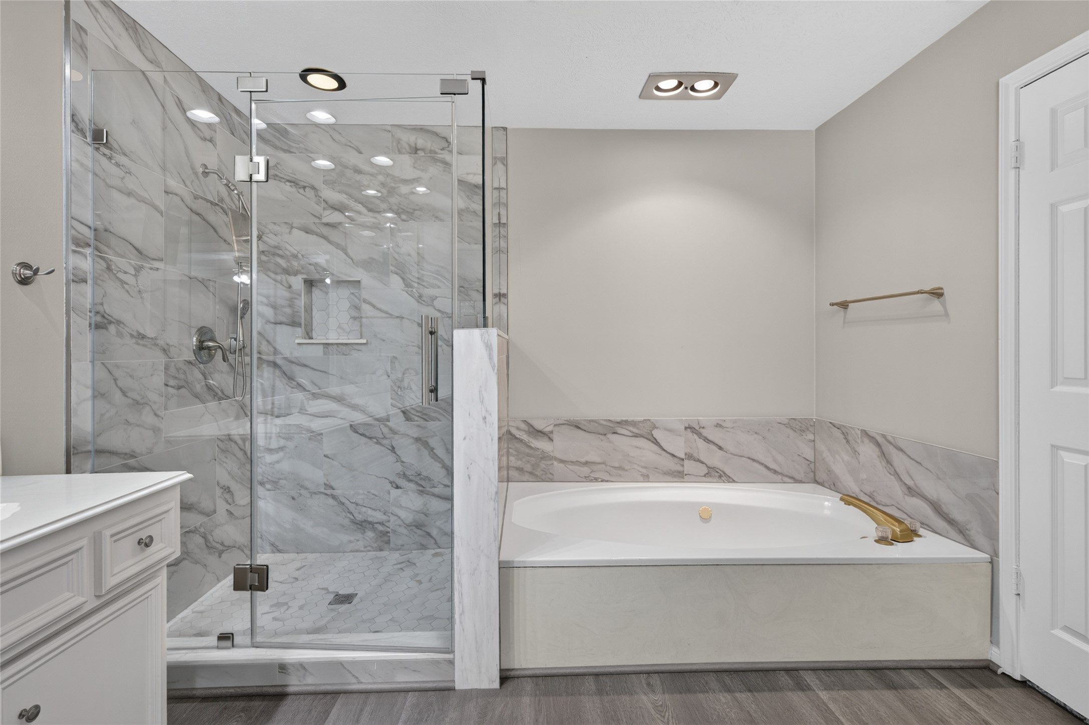 The glass-enclosed shower, marble tile, and soaking tub create a relaxing space where buyers can imagine starting the morning refreshed or unwinding at the end of the day.