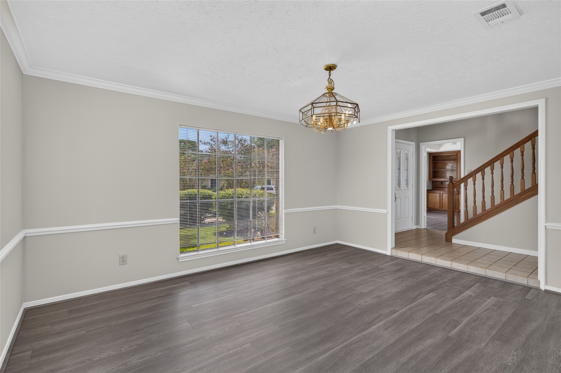 Natural light, crown molding, and a beautiful chandelier give this room an elegant foundation for everyday living, entertaining, or creating a comfortable gathering space of your own.