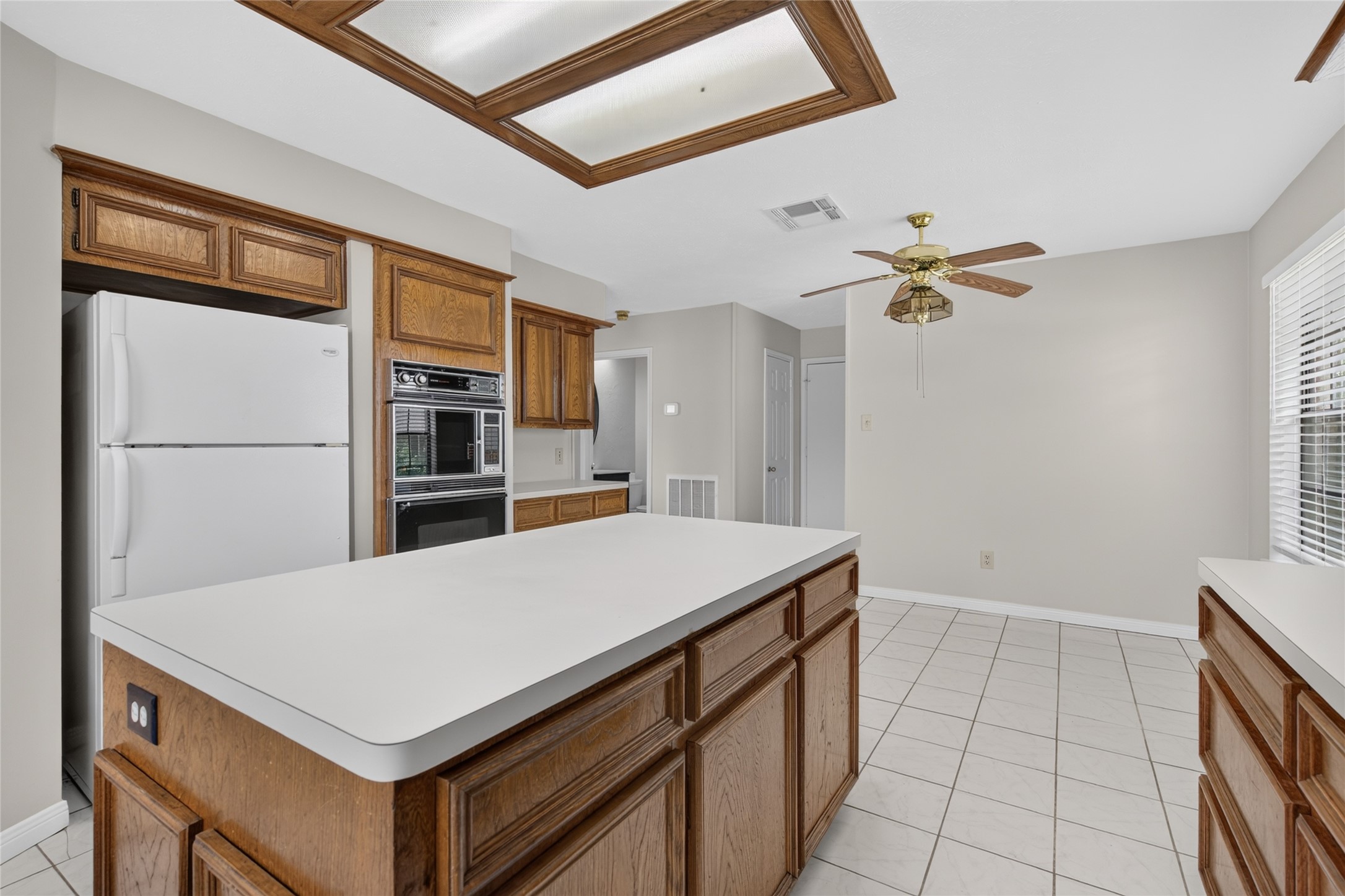 The spacious island provides a natural gathering point while the surrounding cabinetry and bright neutral finishes create an open, comfortable setting for cooking, conversation, and everyday life.